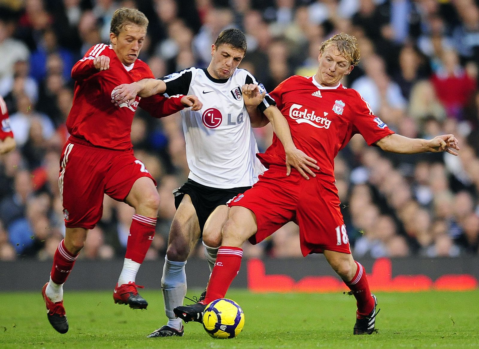 Fulham's Baird is challenged for the ball by Liverpool's Kuyt and Leiva during their English Premier League soccer match in London