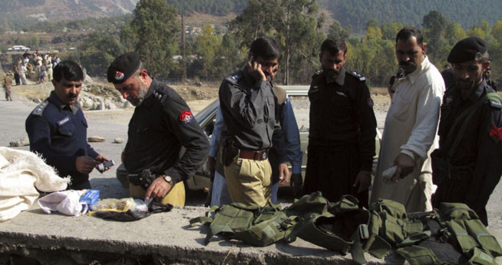 Pakistani police inspect the suicide jackets recovered from a car after a shootout in Mansehra