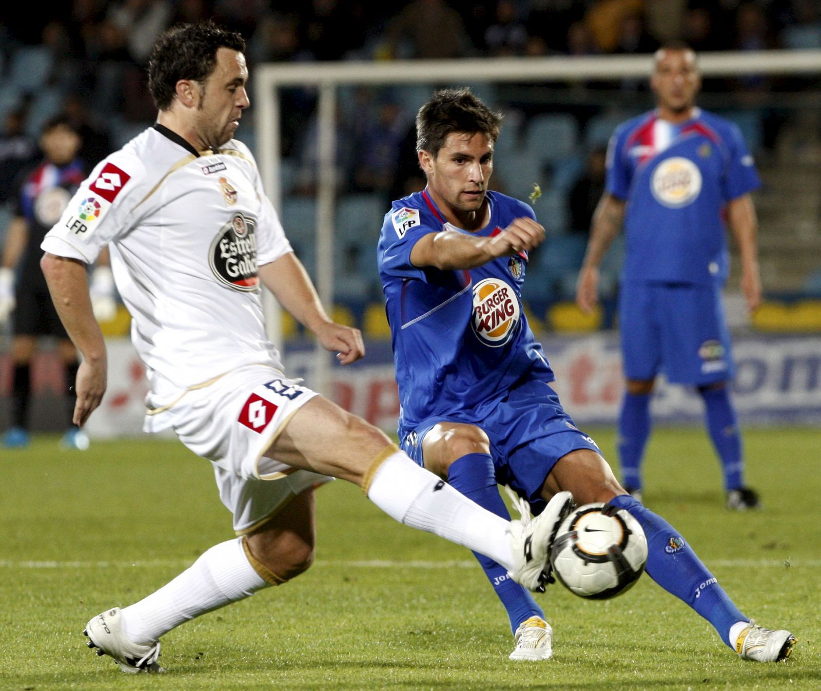 El centrocampista del Getafe Adrián González pelea un balón con el centrocampista del Deportivo Sergio González.