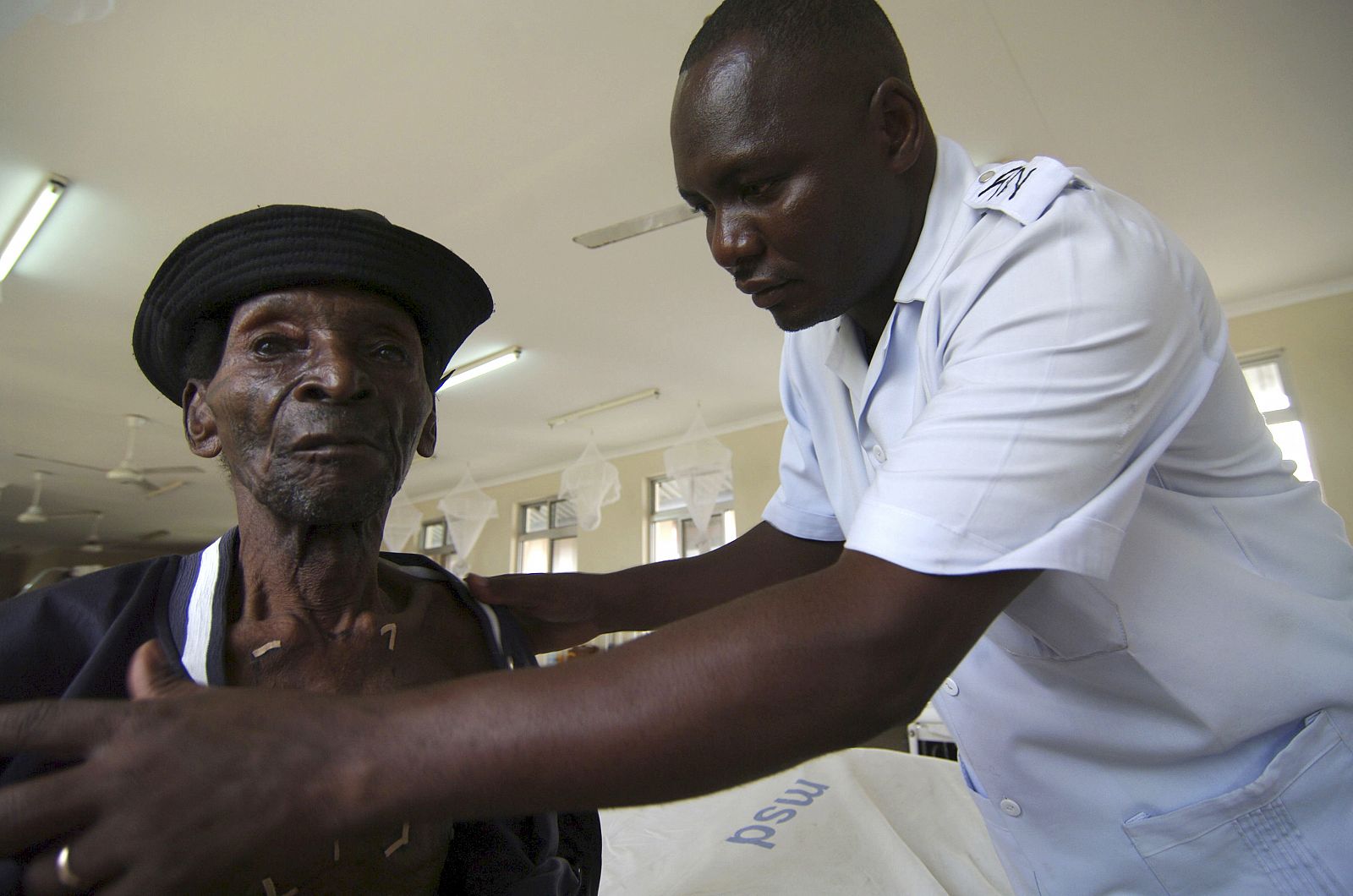 Un enfermero ariende a un paciente de cáncer en Tanzania.