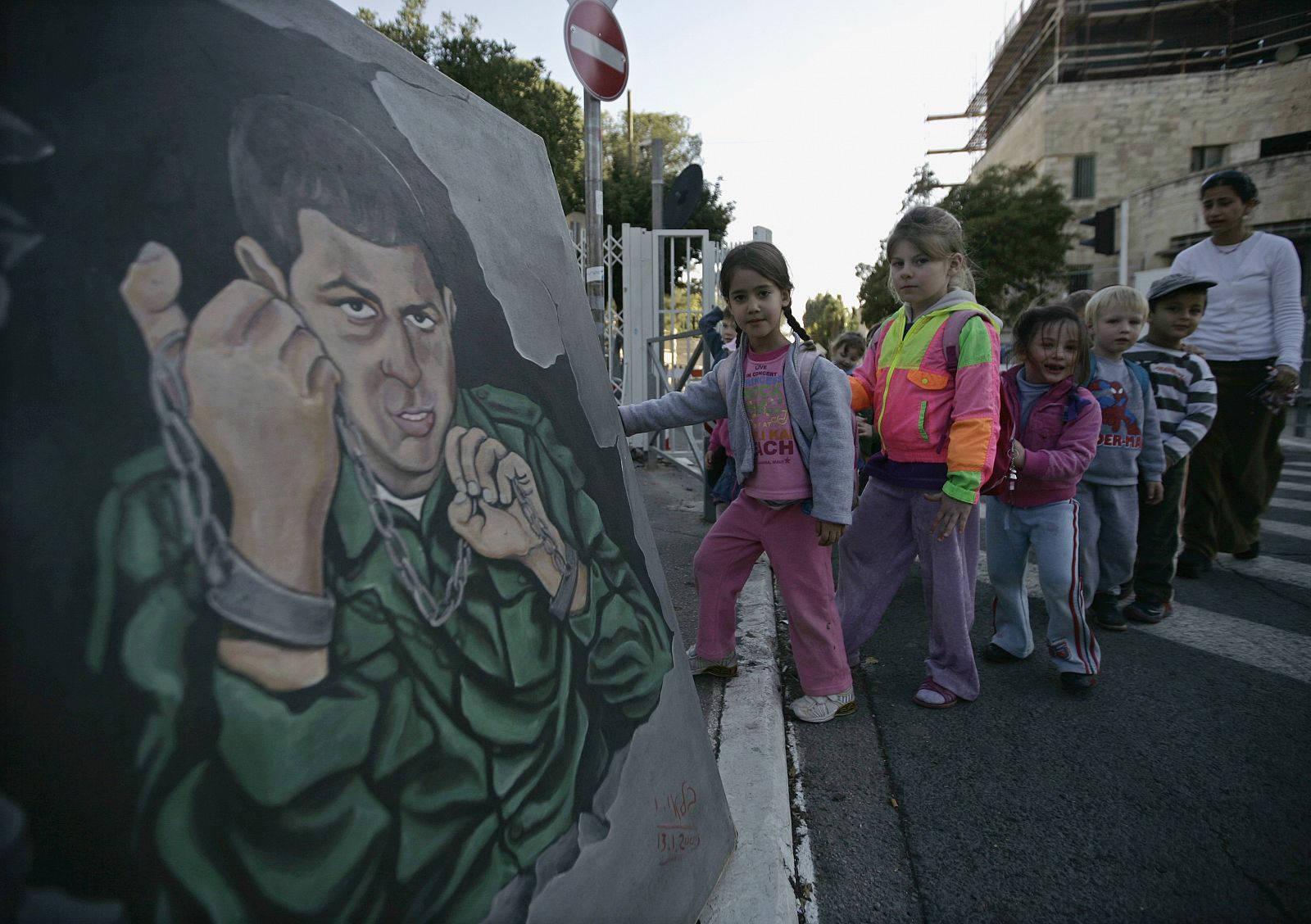 Niños israelíes cruzan ante el mural en homenaje a Gilad Shalit en Jerusalén.