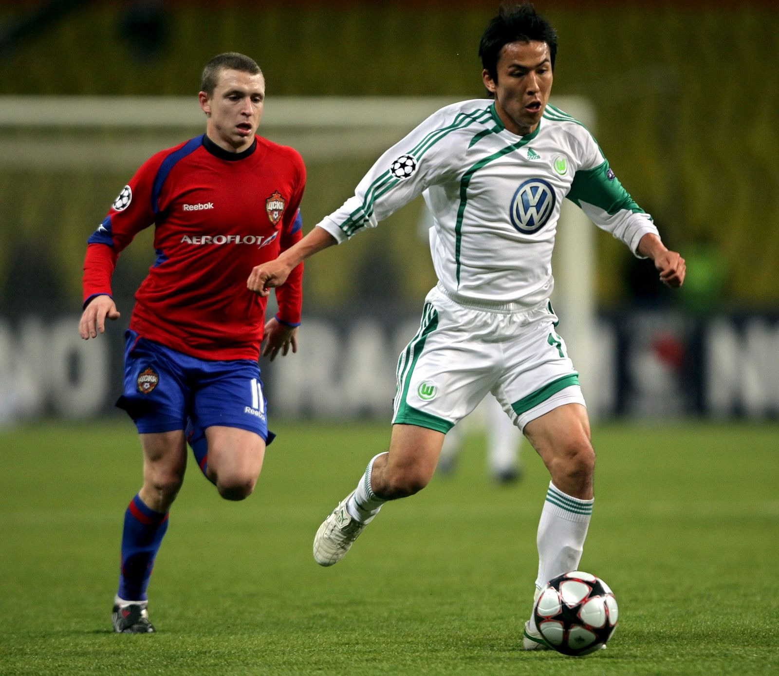 El mediocampista del CSKA de Moscú, Pavel Mamayev (i), lucha por el balón con el japonés Makoto Hasebe (d), del VfL Wolfsburgo