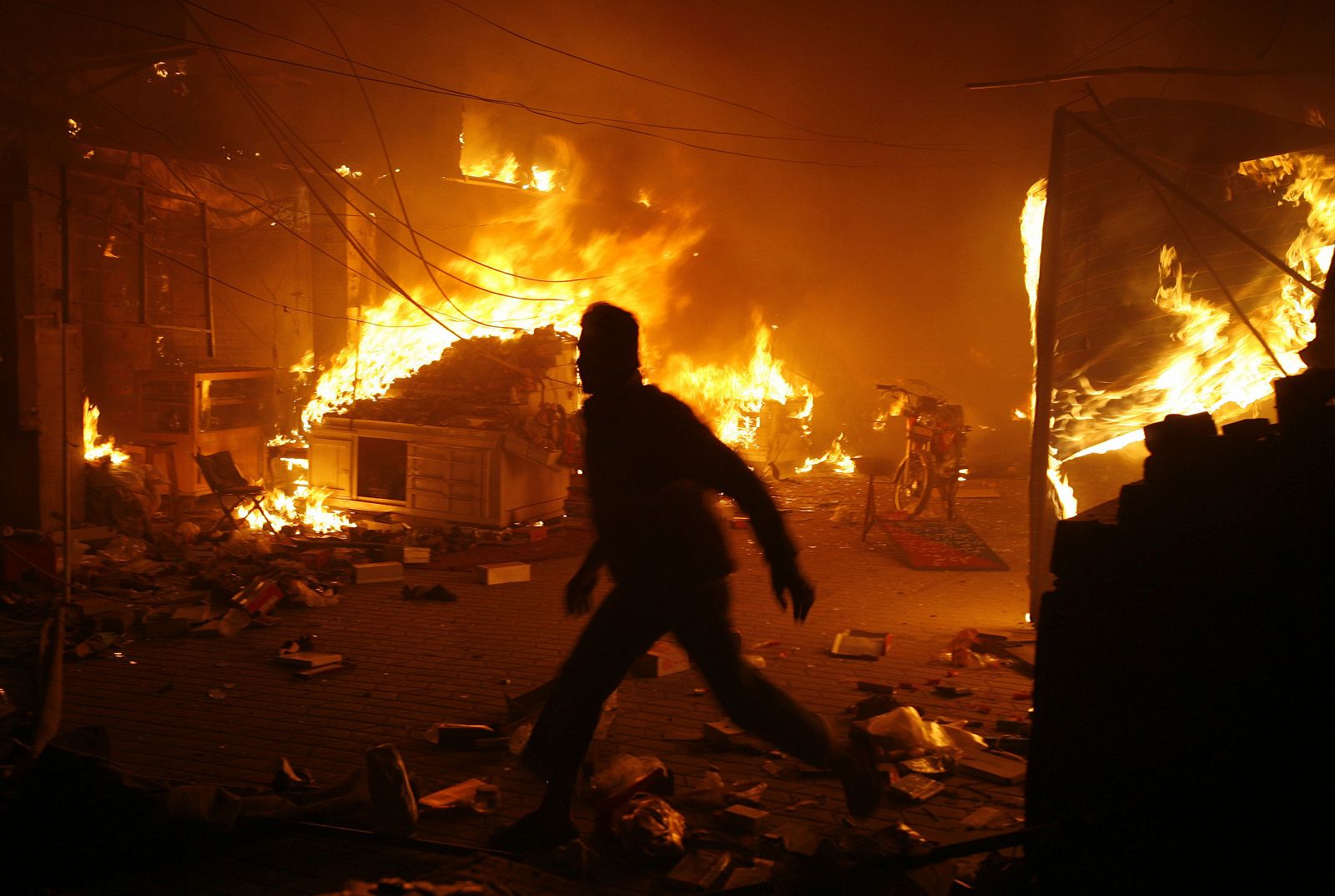 Un hombre traspasa una llama tras la explosión en el mercado de Lahore.