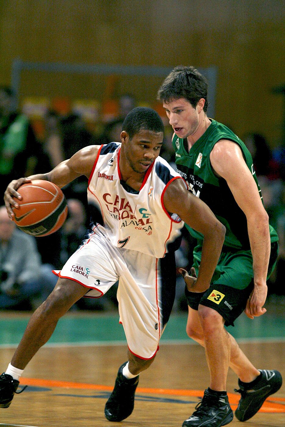 El base norteamericano del Caja Laboral Baskonia, Sean Singletary avanza ante el bloqueo del base del DKV Juventut, Mario Fernández, en el partido de ida.