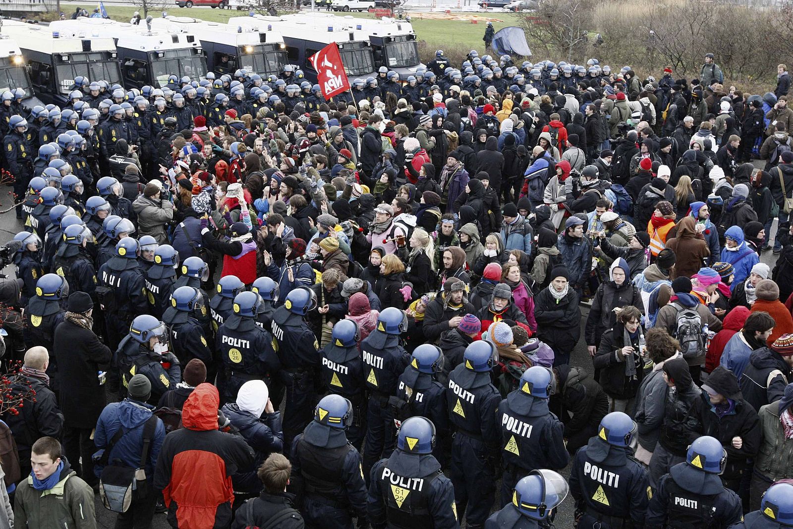 Policías vigilan a los manifestantes de la cumbre de la ONU sobre Cambio Climático en Copenhague.