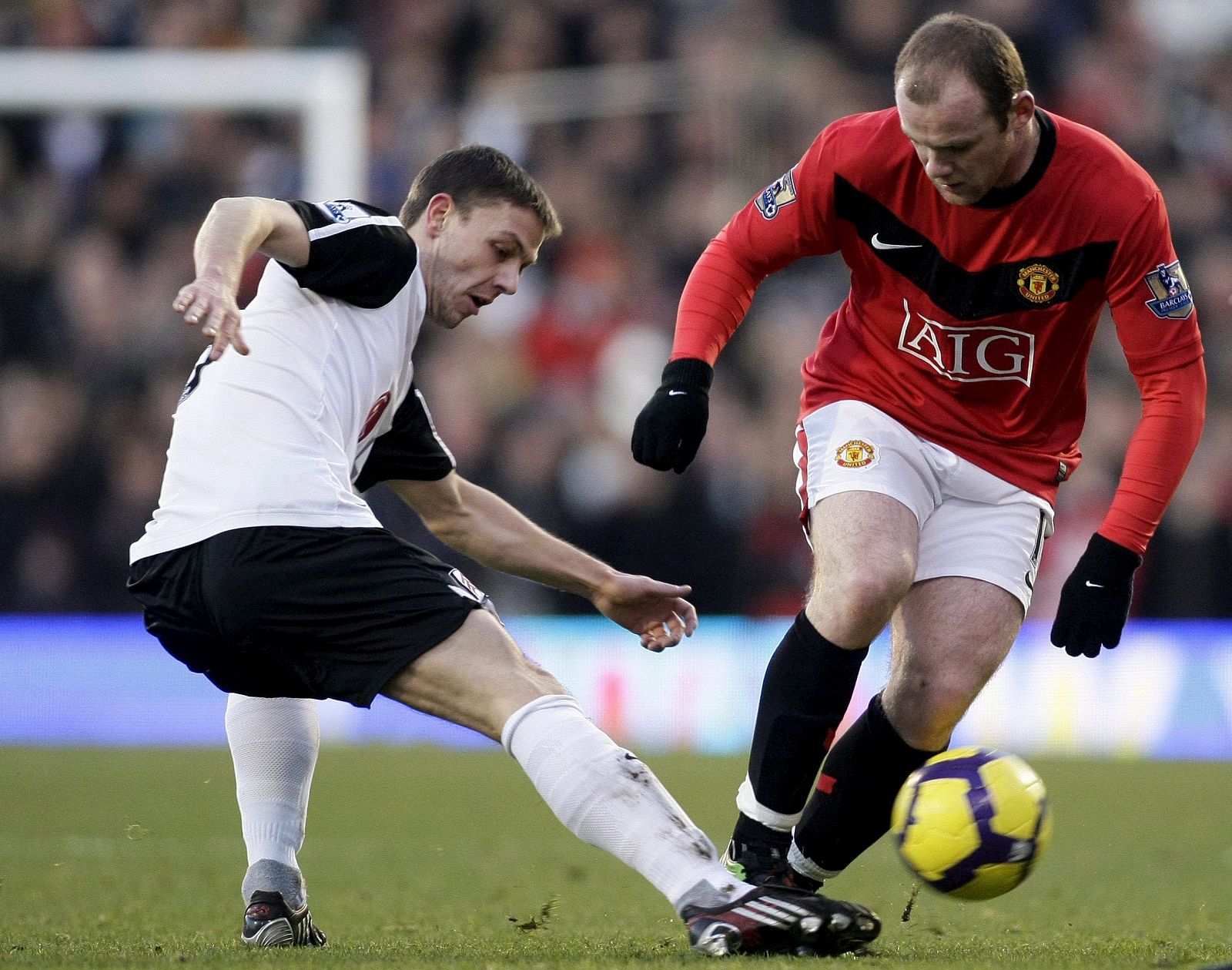 Rooney lucha por el balón con Chris Bird durante el partido disputado en el Craven Cottage.