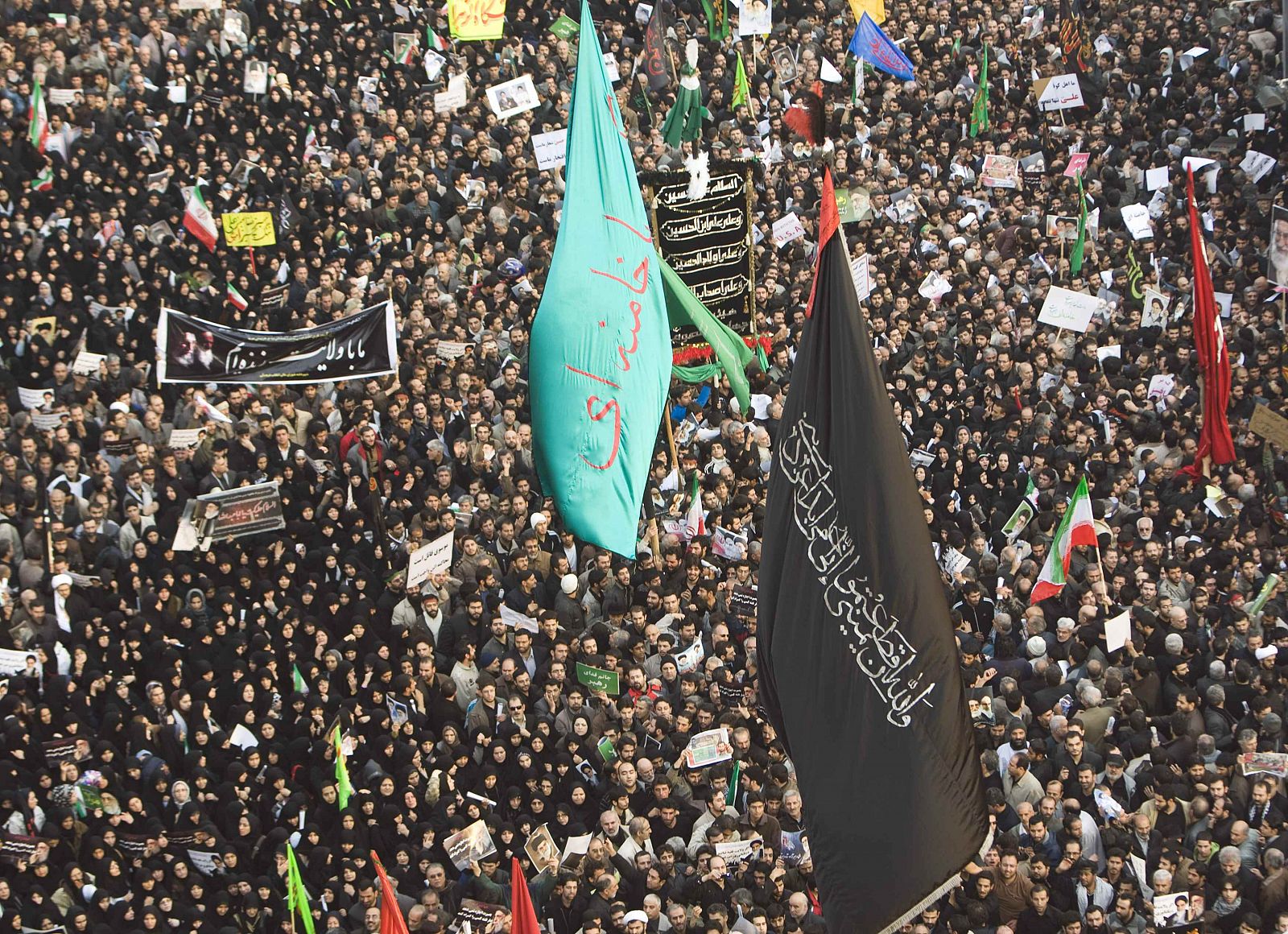 Los partidarios del régimen iraní sostienen una bandera verde con el nombre del líder supremo, el ayatolá Ali Jameneí, en una manifestación en Teherán.