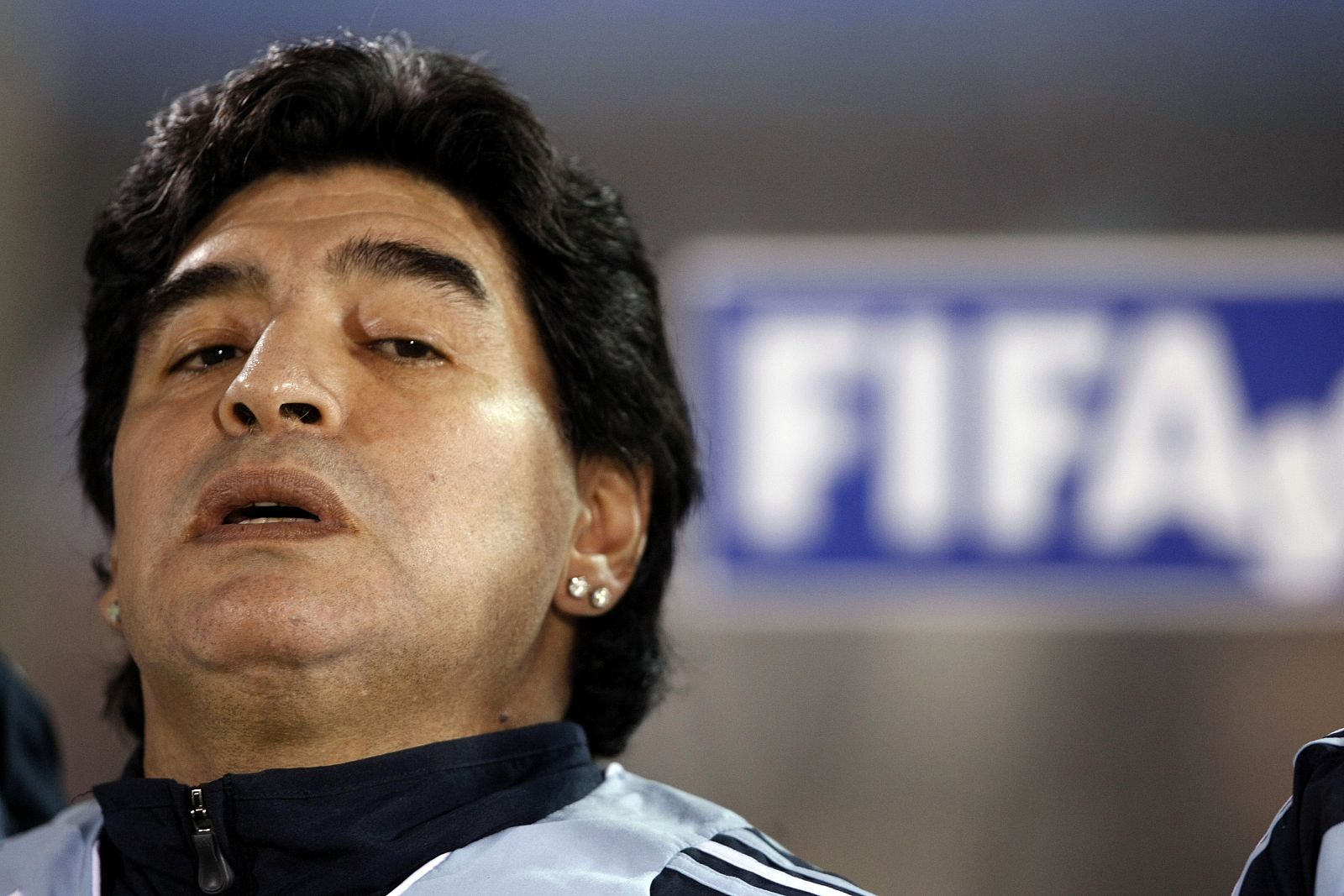 Maradona luciendo sus pendientes en el banquillo de la selección argentina