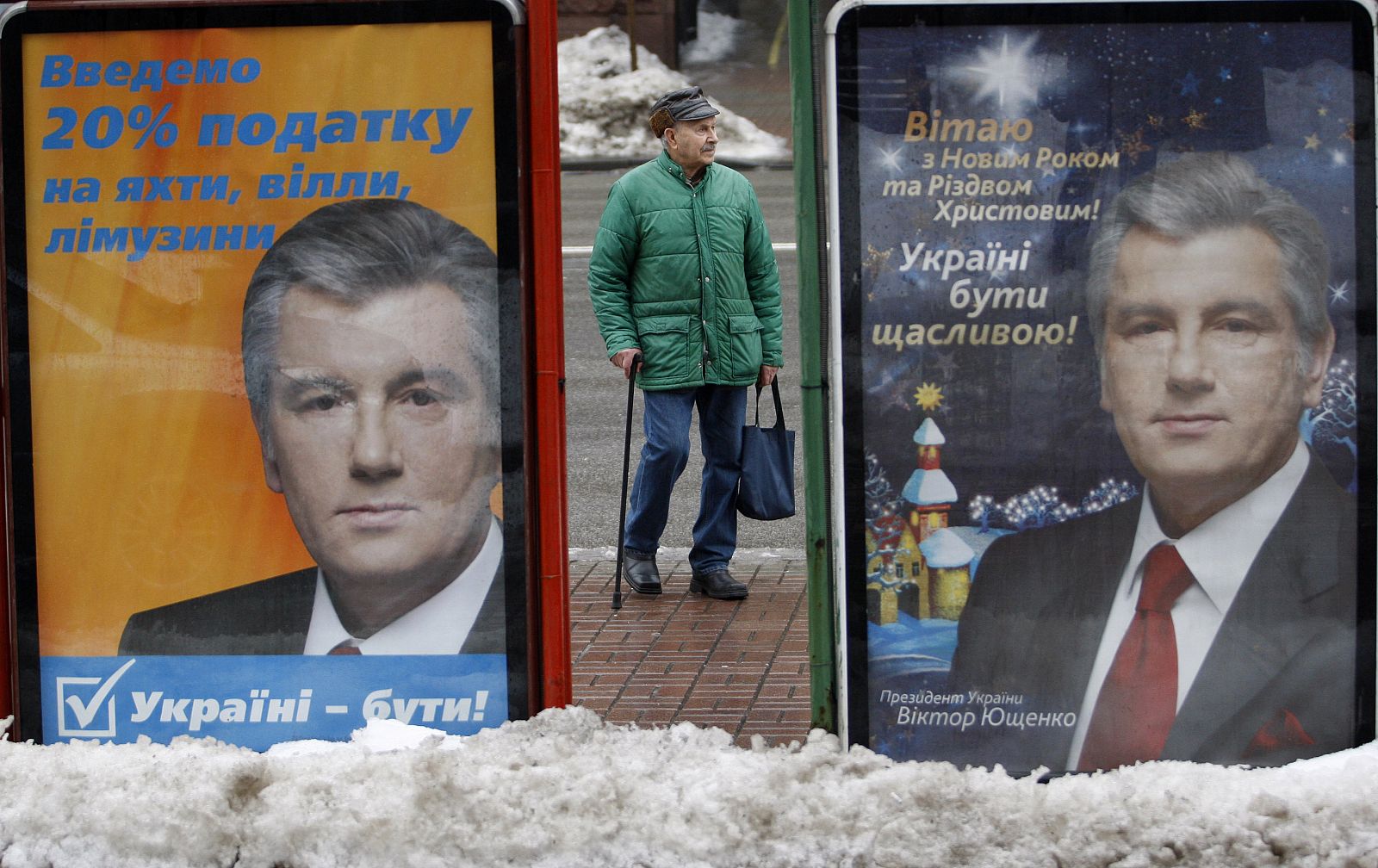 Un hombre en una parada de autobús de Kiev entre carteles del presidente Yushchenko.