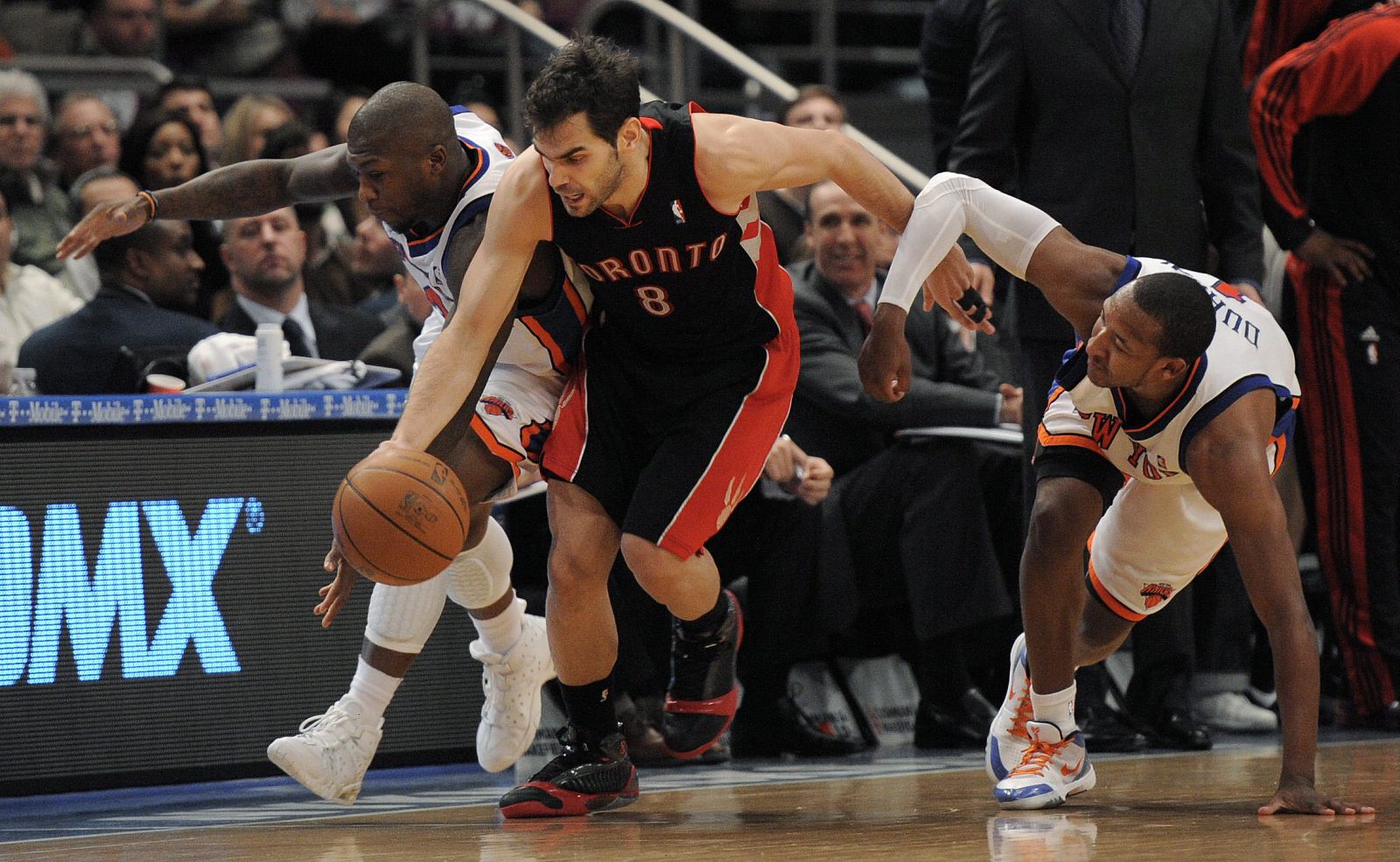 El jugador español de los Raptors de Toronto José Calderón lucha por el balón con Nate Robinson y Chris Duhon de los Knicks de Nueva York.