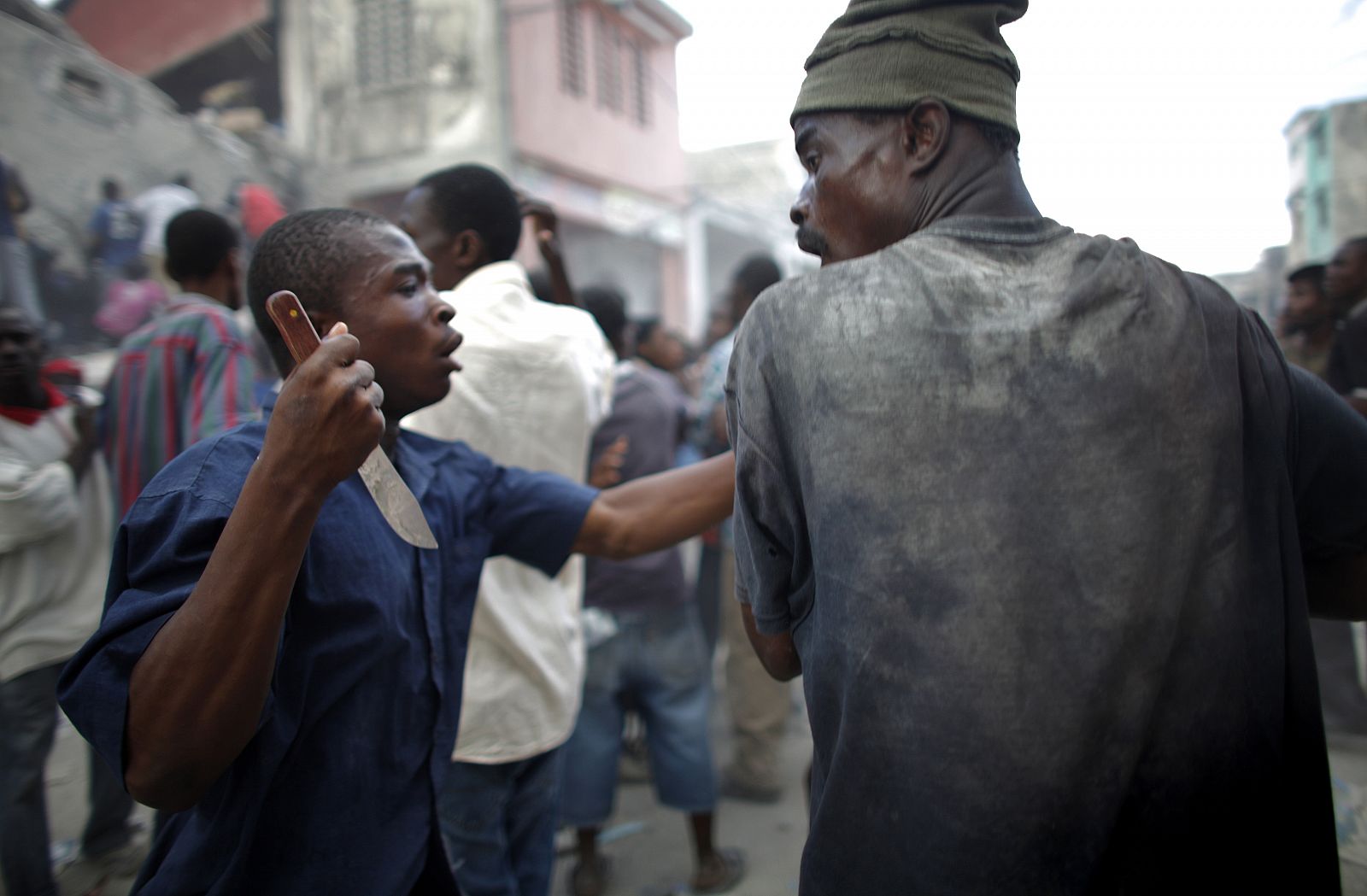A looter holds a knife as he fights for products  after Tuesday's earthquake in Port-au-Prince