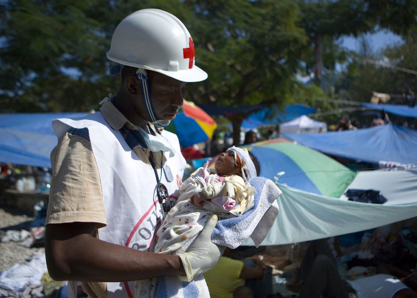 Un trabajador de Cruz Roja ayuda a un bebé herido en Puerto Príncipe.