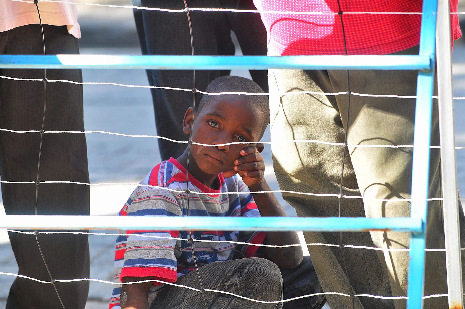 Un niño espera noticias de sus familiares en las afueras del Hospital General de Puerto Príncipe.