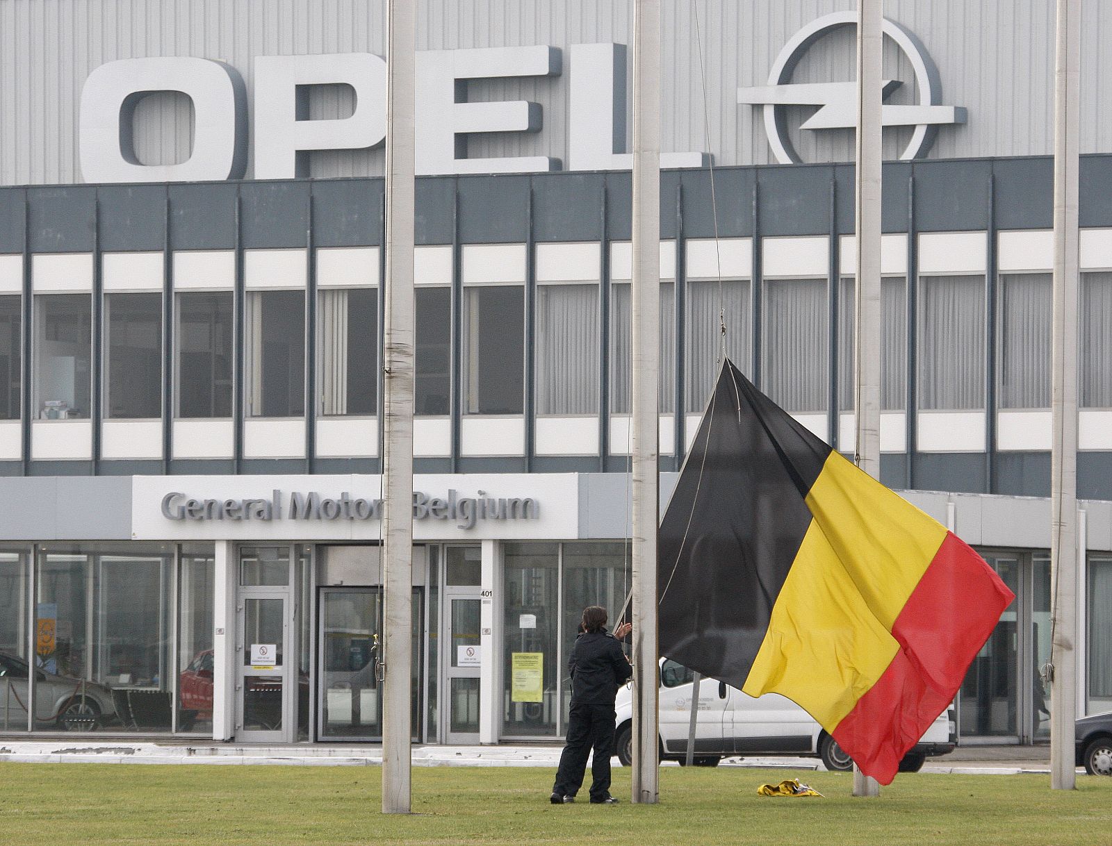 Workers at the Opel assembly plant in Antwerp fly a Belgian national flag at half mast outside the factory in Antwerp