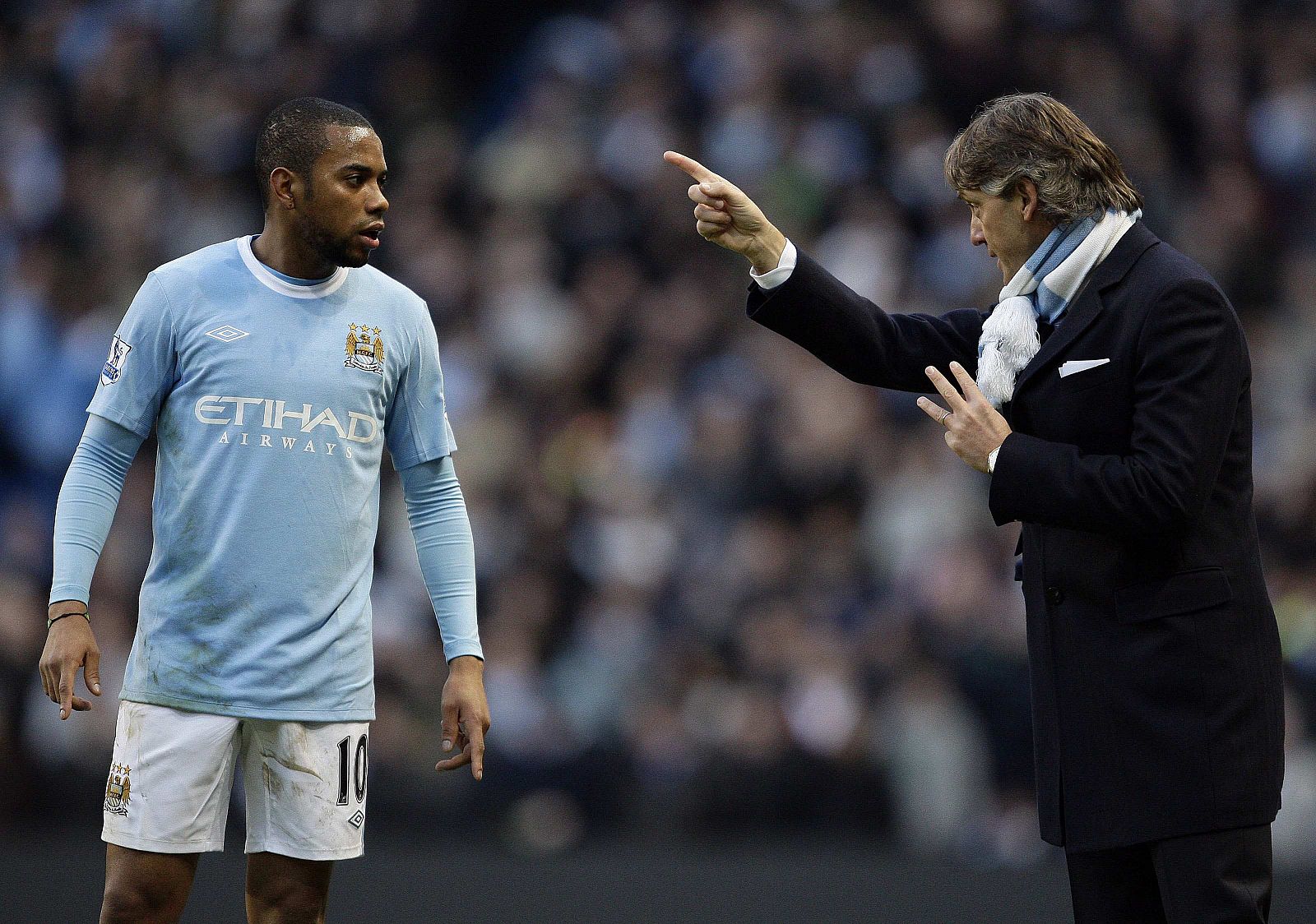 Robino habla con su entrenador en el Manchester City, Mancini.