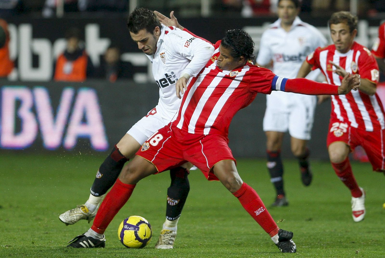 El defensa del Almería, Wilmer Acasiete, lucha por el balón ante el delantero del Sevilla, Álvaro Negredo.