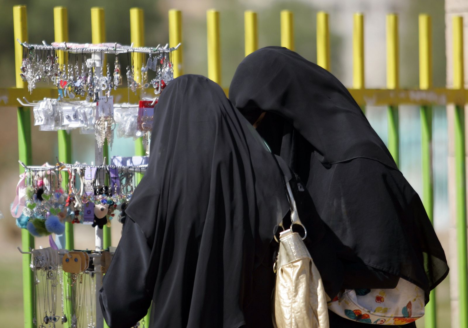Dos mujeres vestidas con velos compran accesorios en un puesto ambulante en Sanaa en Yemen.