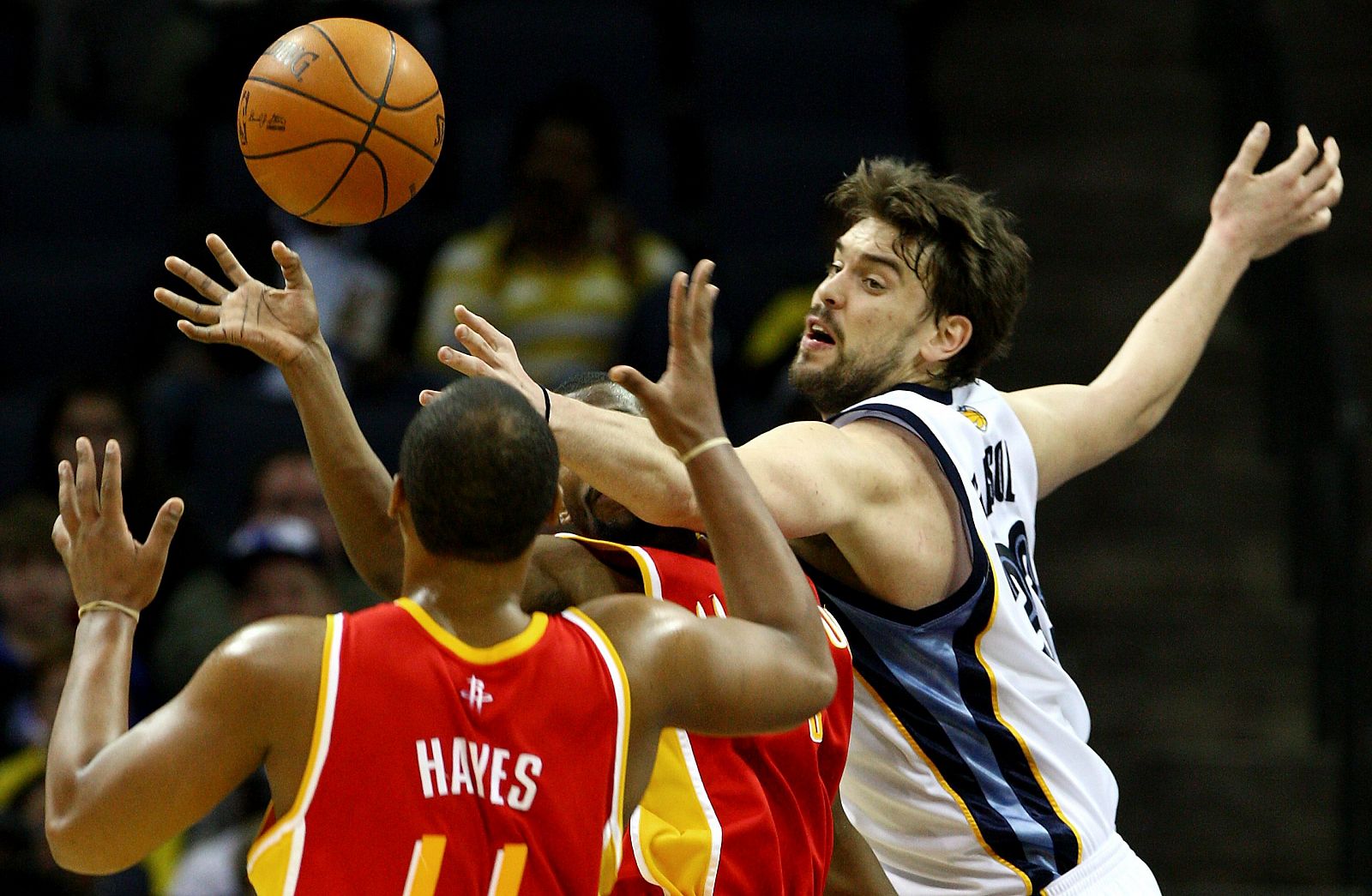 El jugador español de los Grizzlies de Memphis Marc Gasol disputa un balón con Chuck Hayes (i) y Trevor Ariza (c) de los Rockets de Houston.