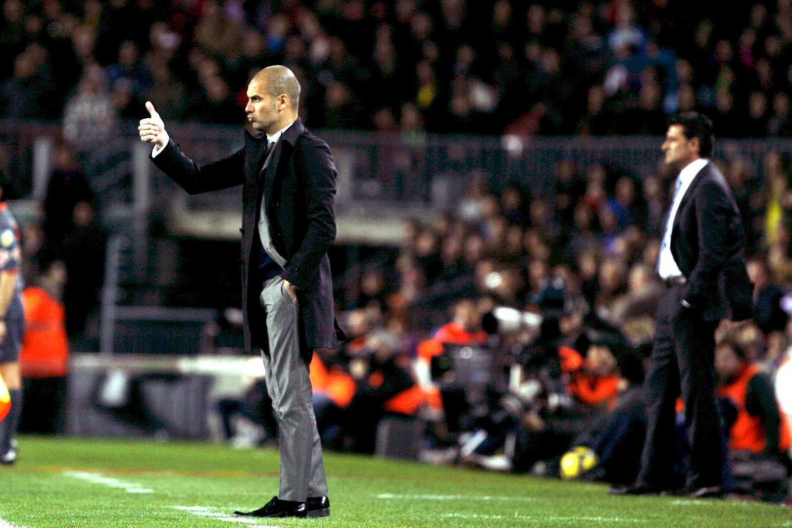 Guardiola, en primer término, da instrucciones a sus jugadores con Míchel al fondo.