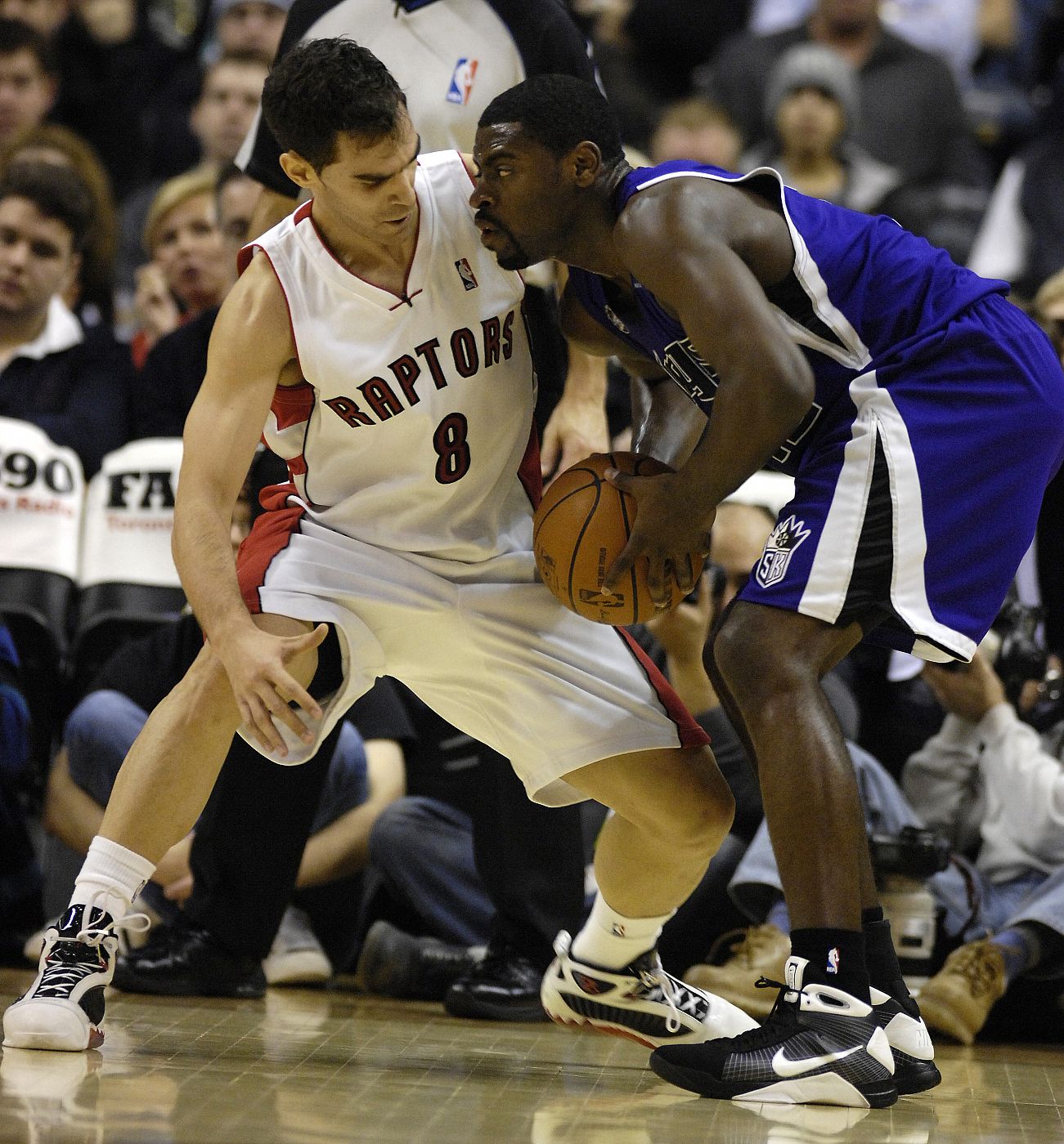 José Calderón de los Raptors de Toronto (i) marca a Tyreke Evans de los Kings de Sacramento