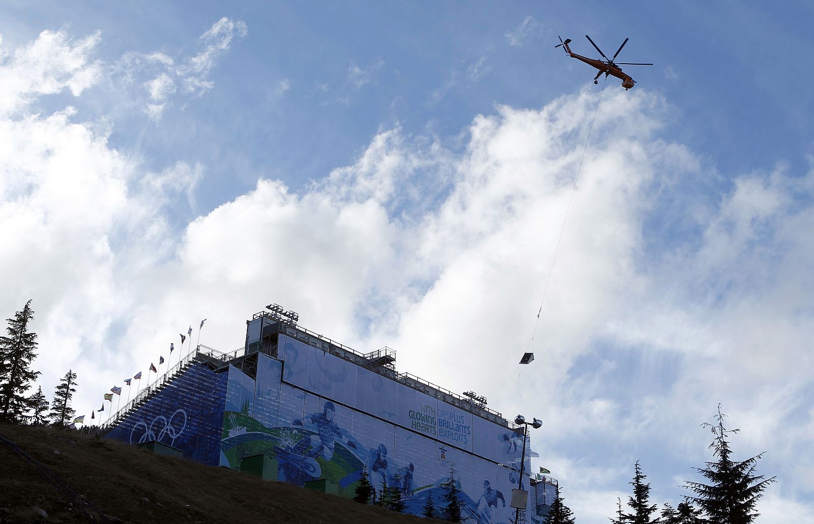 A helicopter transports snow into the snowboard finish area on Cypress Mountain ahead of the Vancouver 2010 Winter Olympics