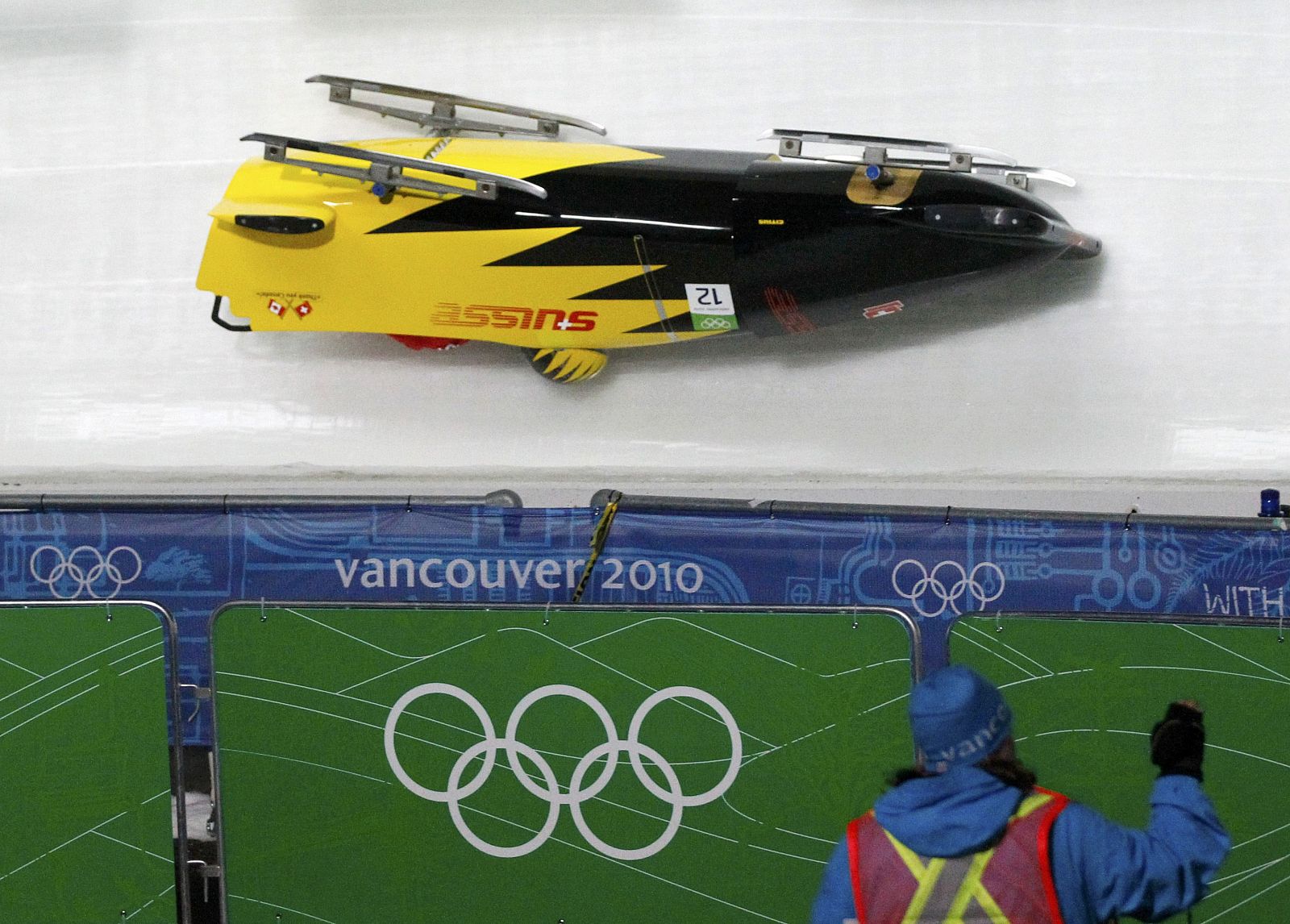 Pilot Schmid and team mate Egger of Switzerland crash during the two-man bobsleigh training heats at the Vancouver 2010 Winter Olympics in Whistler