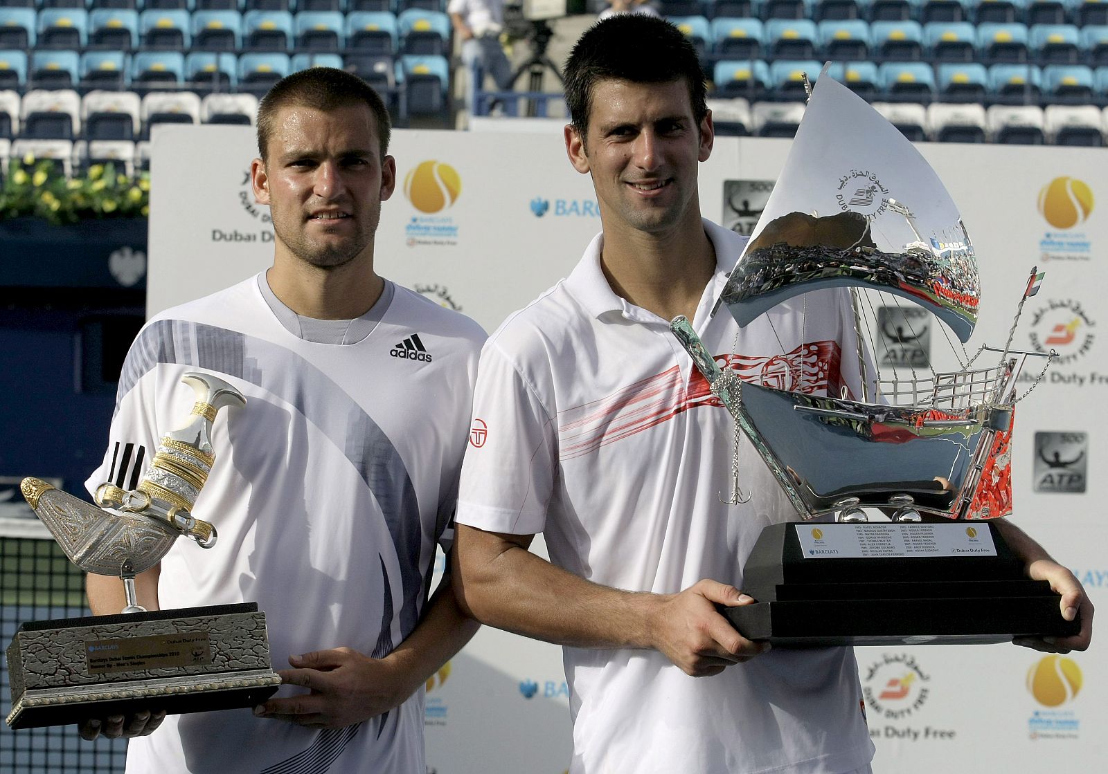 El ruso Youzhny y el serbio Djokovic posan con sus trofeos tras la final del torneo de Dubai.