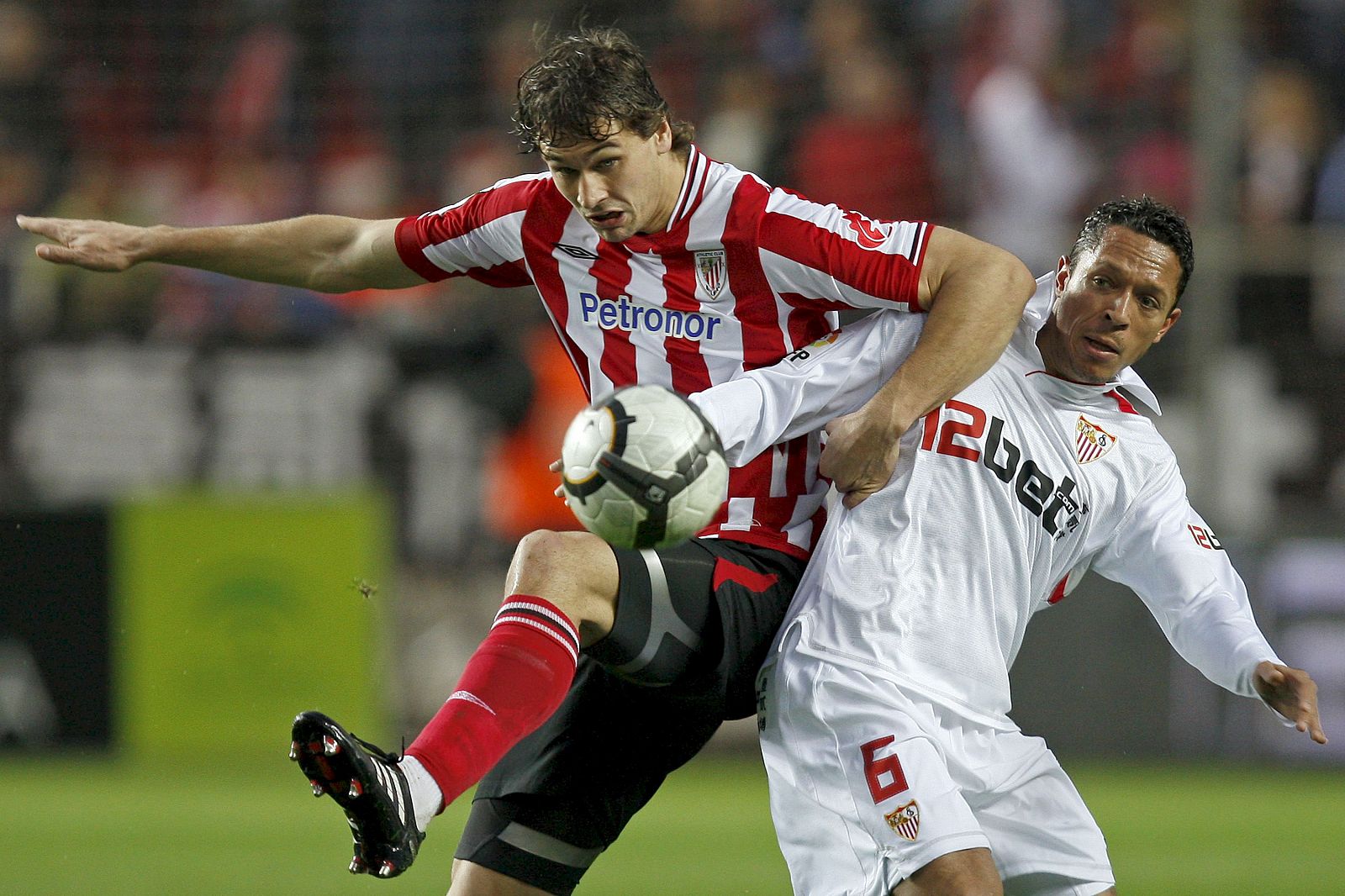El centrocampista brasileño del Sevilla Adriano Correia (d) pelea un balón con el delantero del Athletic de Bilbao Fernando Llorente