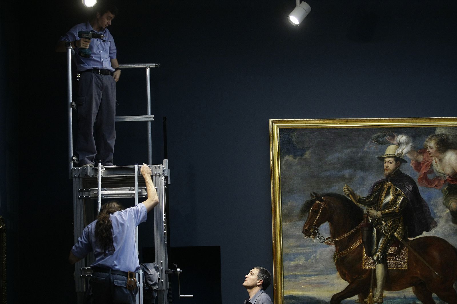 Museum workers are seen next to Rubens' painting "Philip II on Horseback" at Madrid's Prado Museum