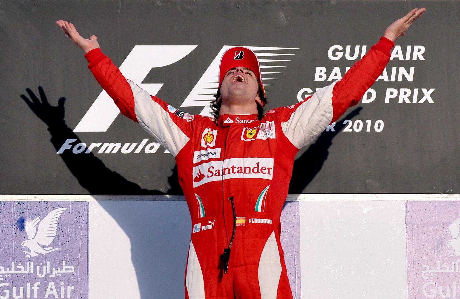 El piloto español de la escudería Ferrari, Fernando Alonso, celebra en el podio su victoria en el Gran Premio de Bahrein.