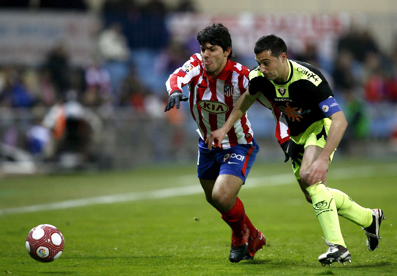 El delantero argentino del Atlético de Madrid Sergio "Kun" Agüero con el osasunista Miguel Flaño