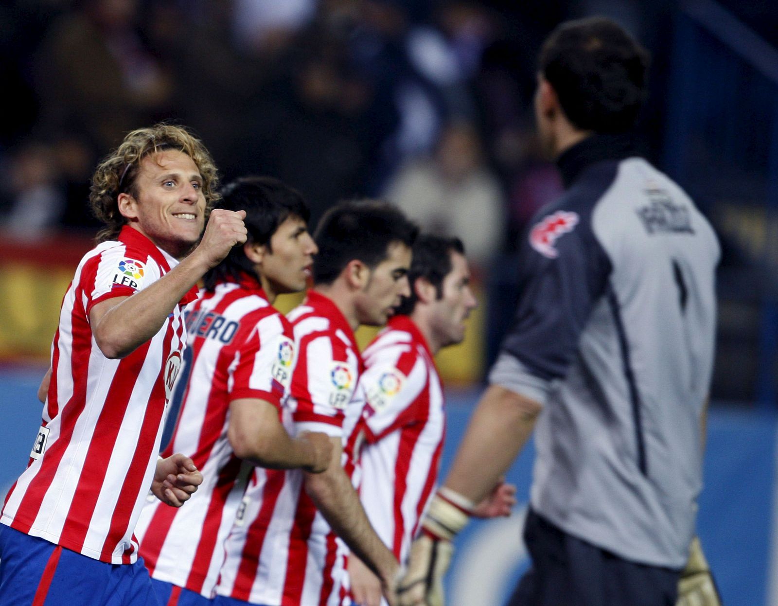 Diego Forlán celebra junto a sus compañeros su gol ante el Athletic, el que abrió el marcador en el Calderón.