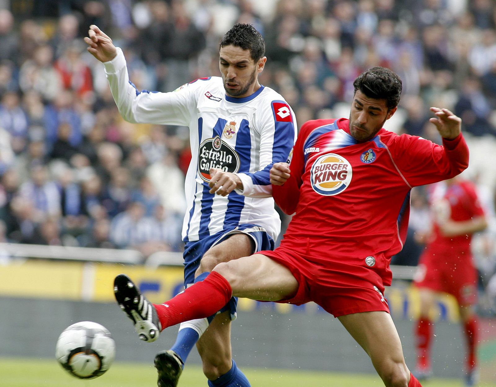 El delantero del Deportivo Lassad Nouioui (i) lucha con el defensa del Getafe Miguel Torres.