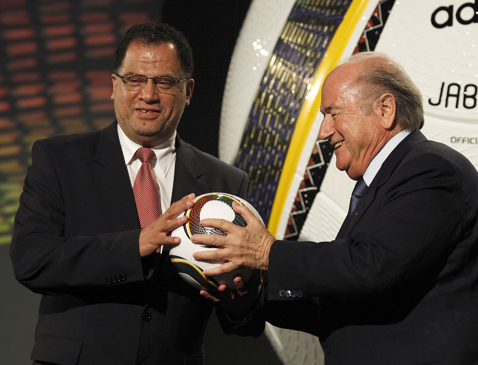 El consejero delegado de la organización del Mundial de Sudáfrica y el presidente de la FIFA, Sepp Blatter, sostienen el balón oficial del torneo.