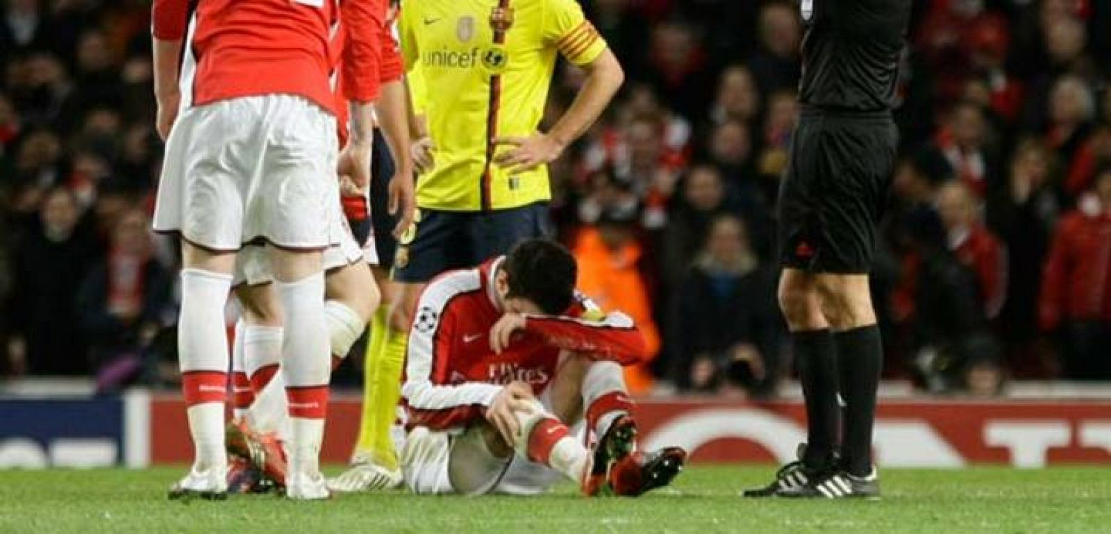 Fábregas se duele de su lesión tendido en el césped del Emirates Stadium.