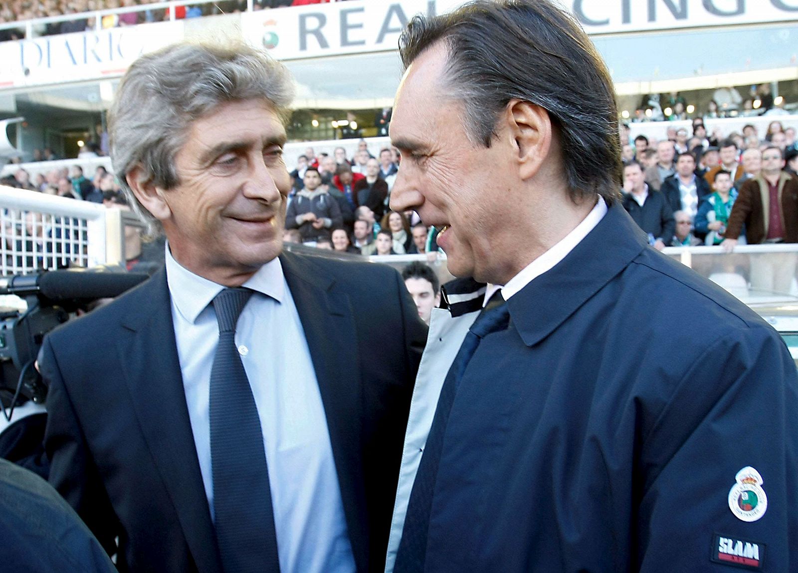 Los entrenadores del Real Madrid, el chileno Manuel Pellegrini (i), y del Racing de Santander, Miguel Ángel Portugal, se saludan momentos antes del comienzo del encuentro