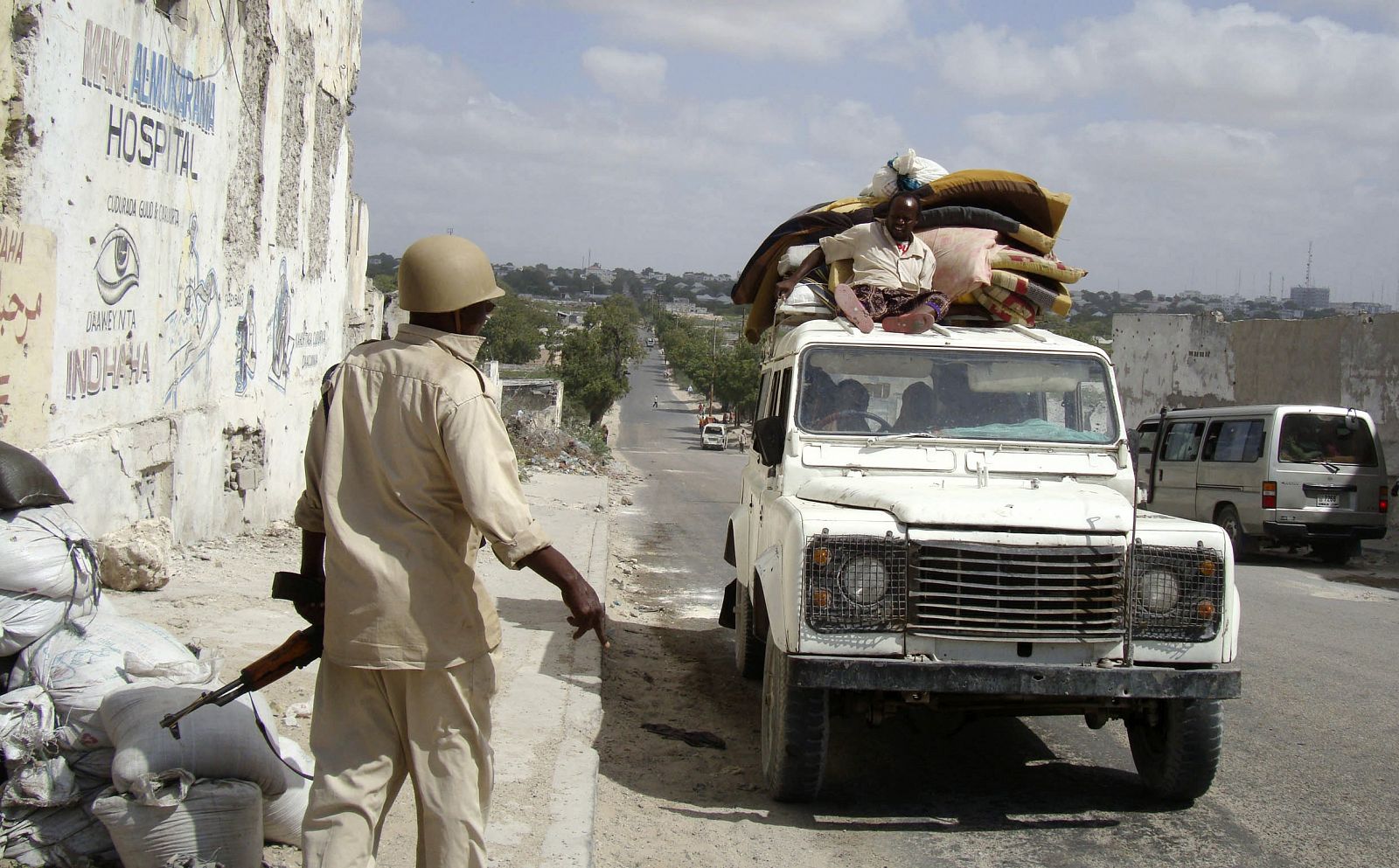 Un soldado del ejército de Somalia para un coche en un control de carretera.