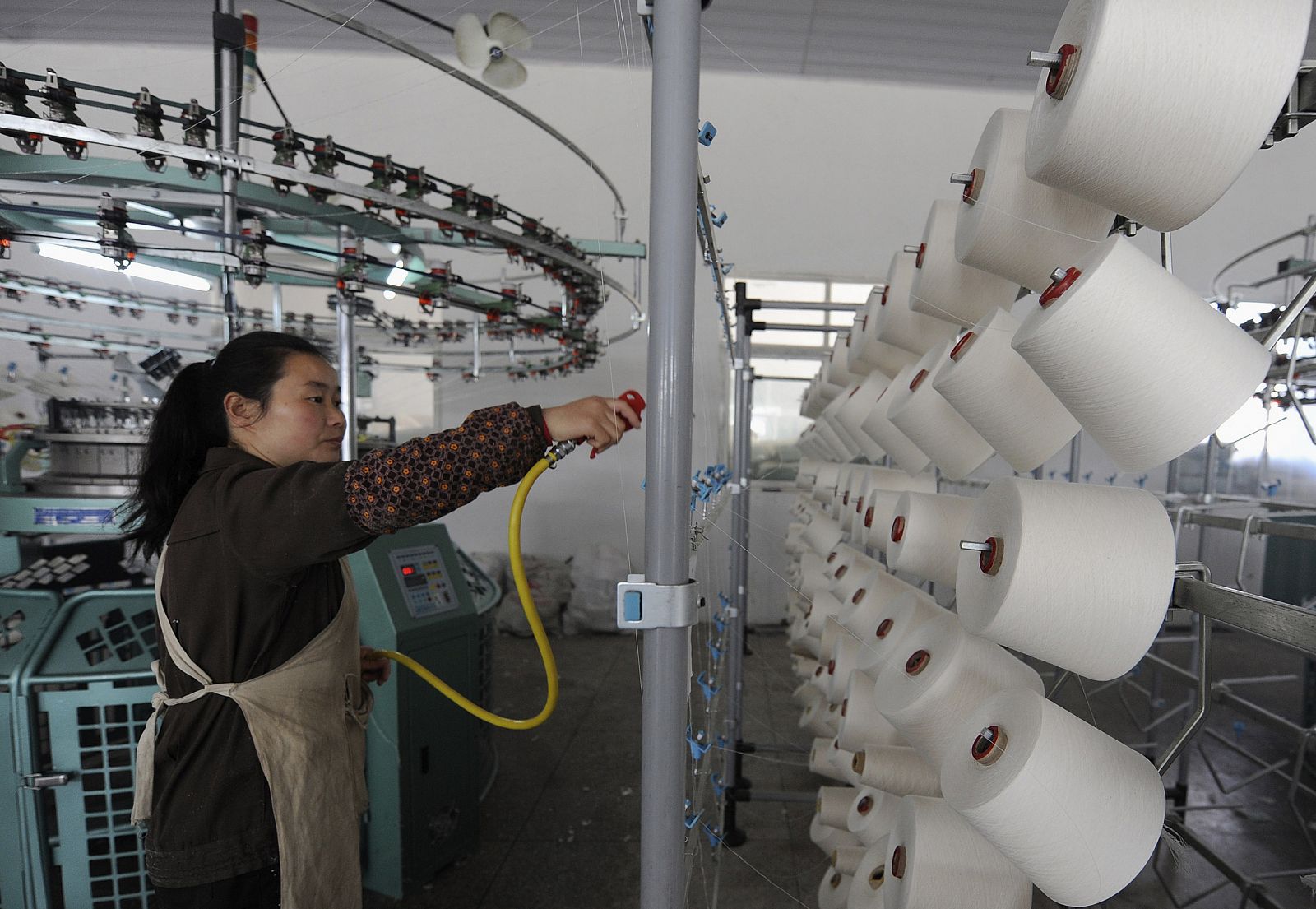 An employee works inside the workshop of a textile mill in Hefei