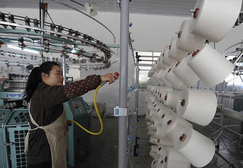 An employee works inside the workshop of a textile mill in Hefei