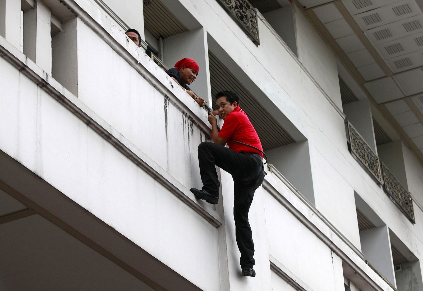 Uno de los líderes de los "camisas rojas" escapa por el balcón del cerco policial en el hotel en el que se alojaban