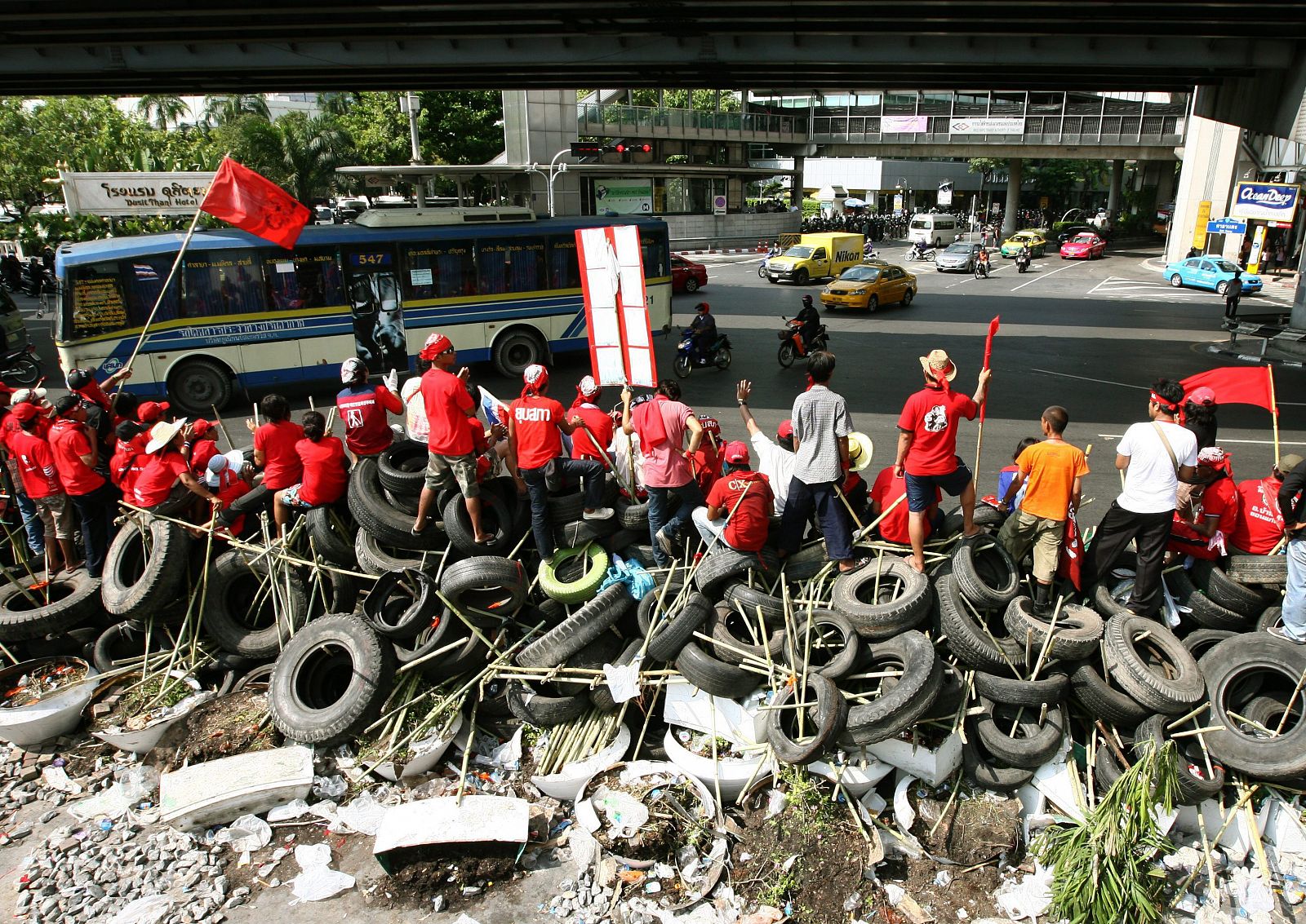 Varios "camisas rojas" permanecen en una barricada hecha con llantas y bambú
