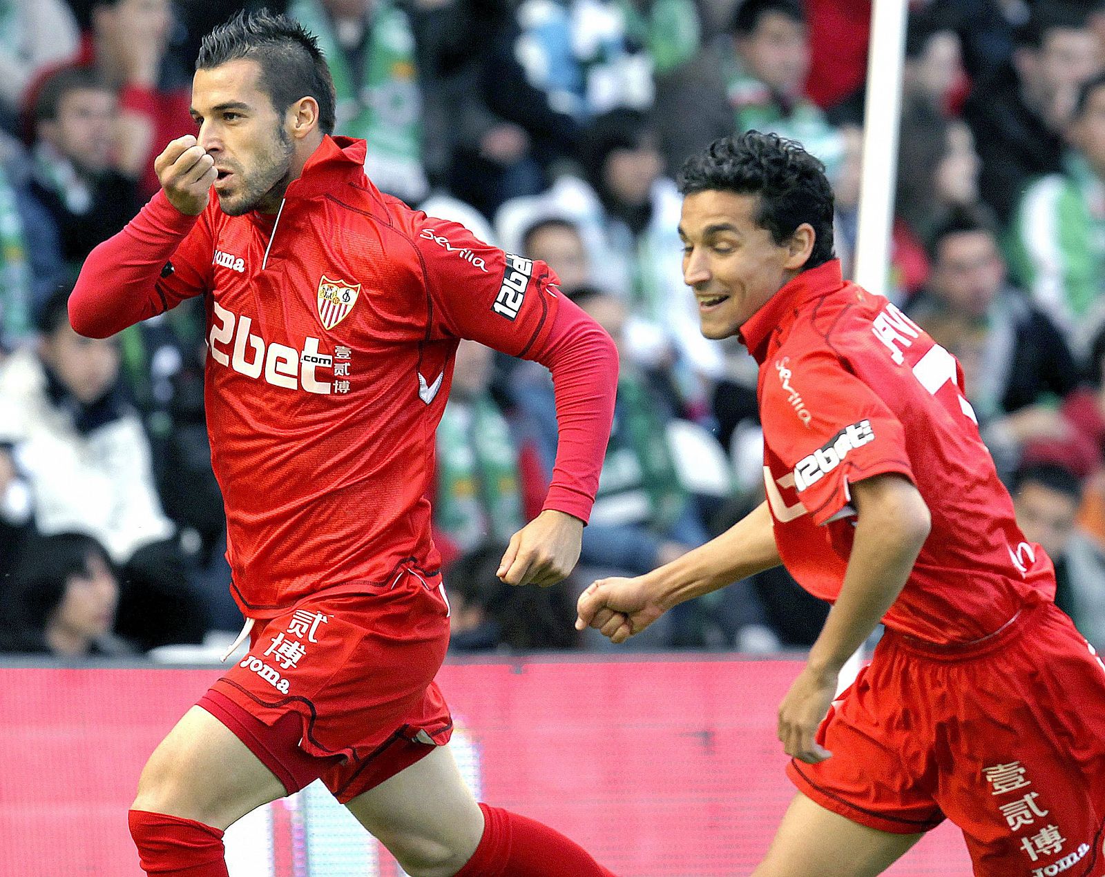 El delantero del Sevilla, Álvaro Negredo, corre perseguido por su compañero, Jesús Navas, para celebrar el primer gol ante el Racing de Santander.