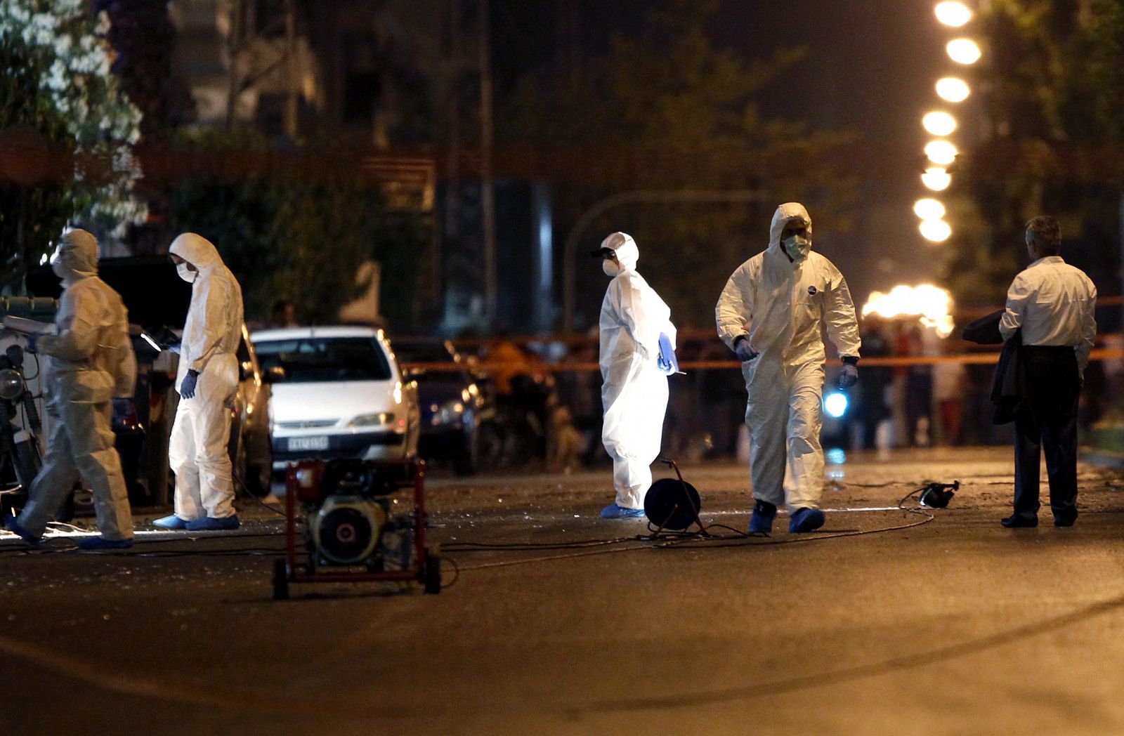 Police investigators search for evidence after a bomb explosion in Athens