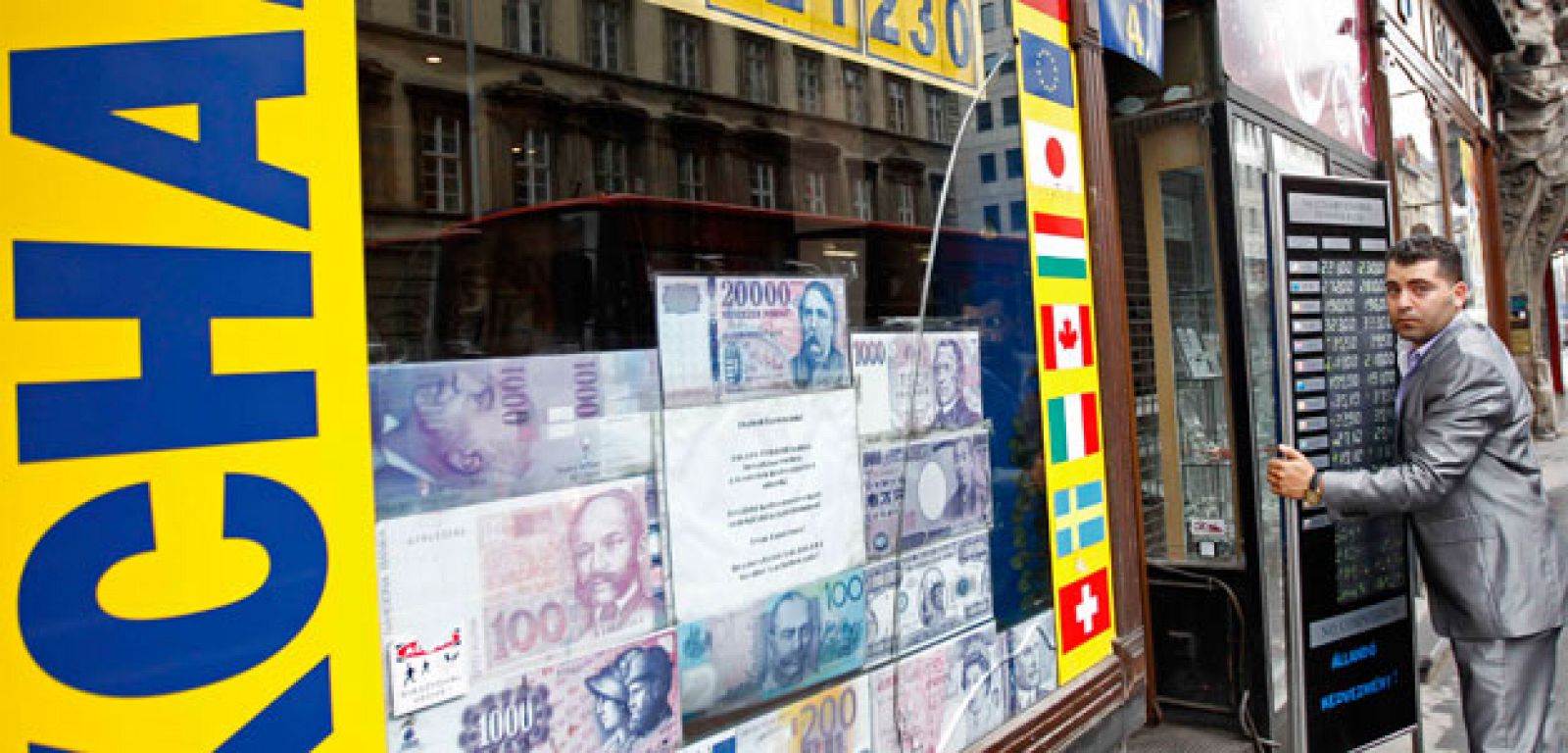 El dependiente de una oficina de cambio de Budapest se prepara para una nueva jornada de nervios de la moneda húngara, el florín.
