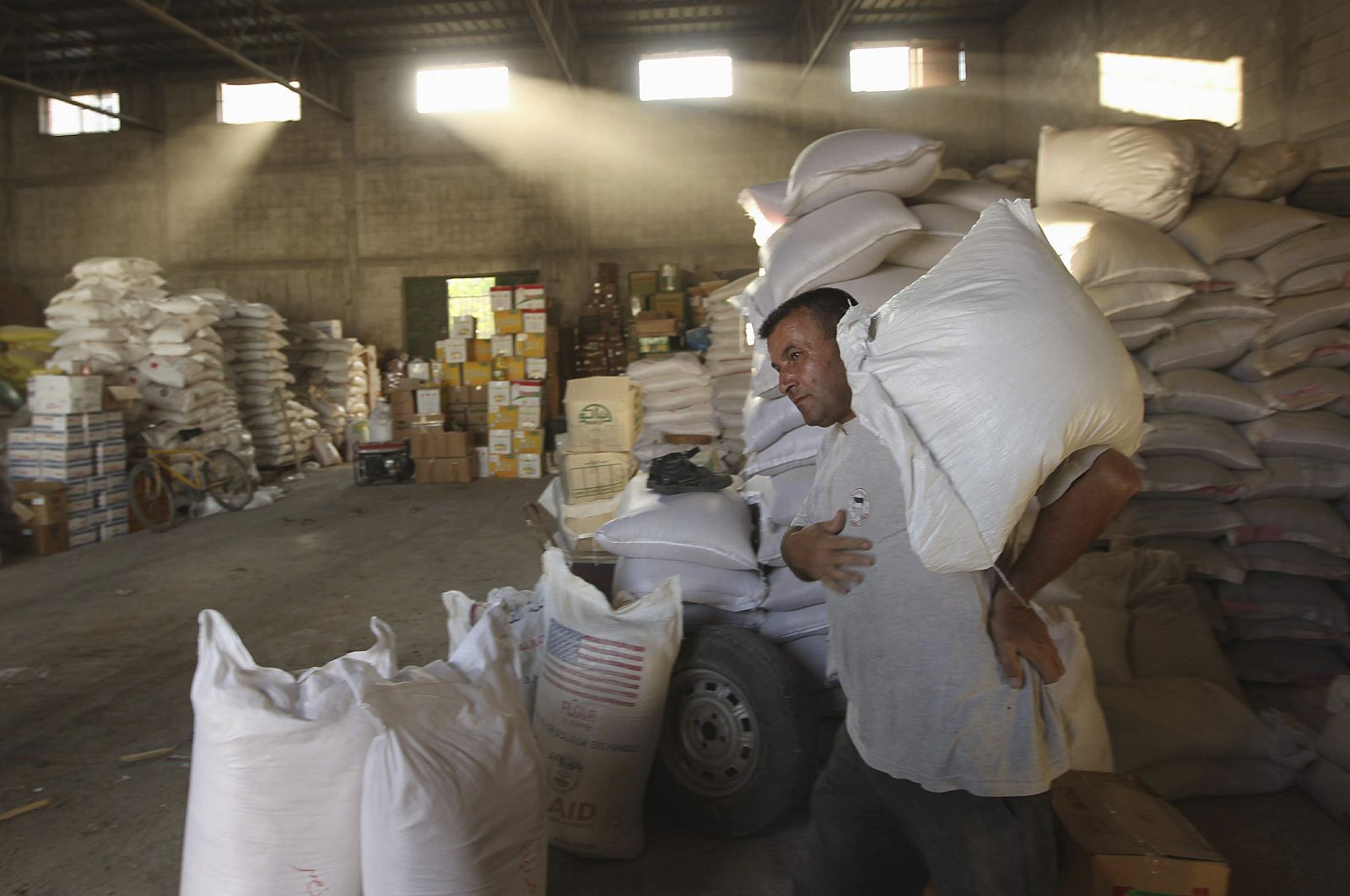 Un hombre se lleva un saco de trigo de una tienda al norte de la Franja de Gaza.