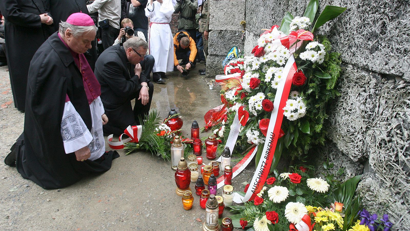 El obispo Tadeusz Rakoczy y el religioso luterano Pawel Anweiler guardan silencio ante el llamado "Muro de la muerte"