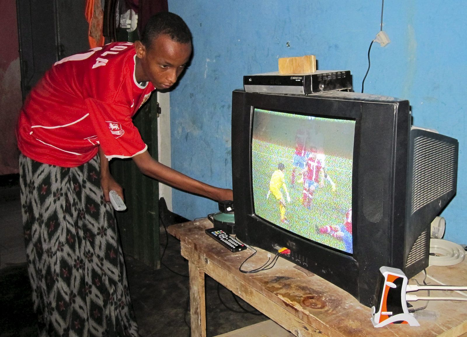 Un somalí sintonizando un televisor para ver el partido del Mundial entre Serbia y Ghana.