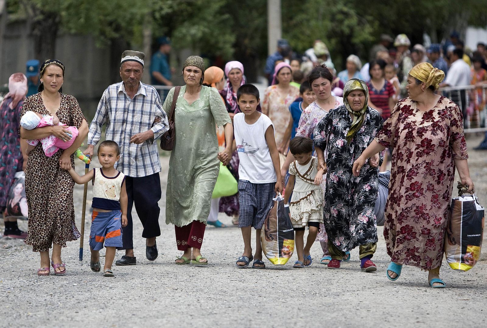 Refugiados de la etnia uzbeka cruzan la frontera para regresar a Kirguizistán.