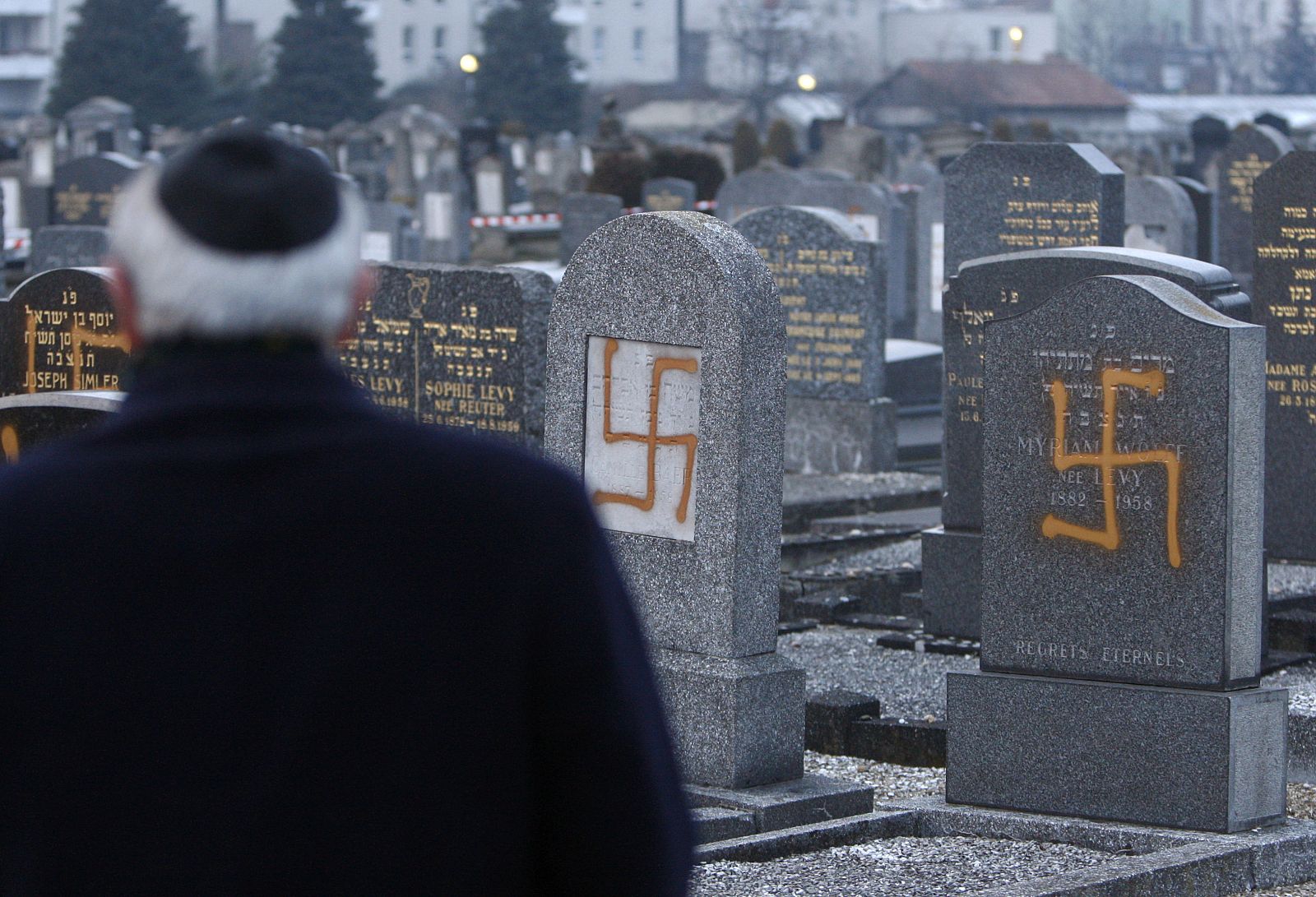 Un judío con su kipá en un cementerio atacado con simbología nazi