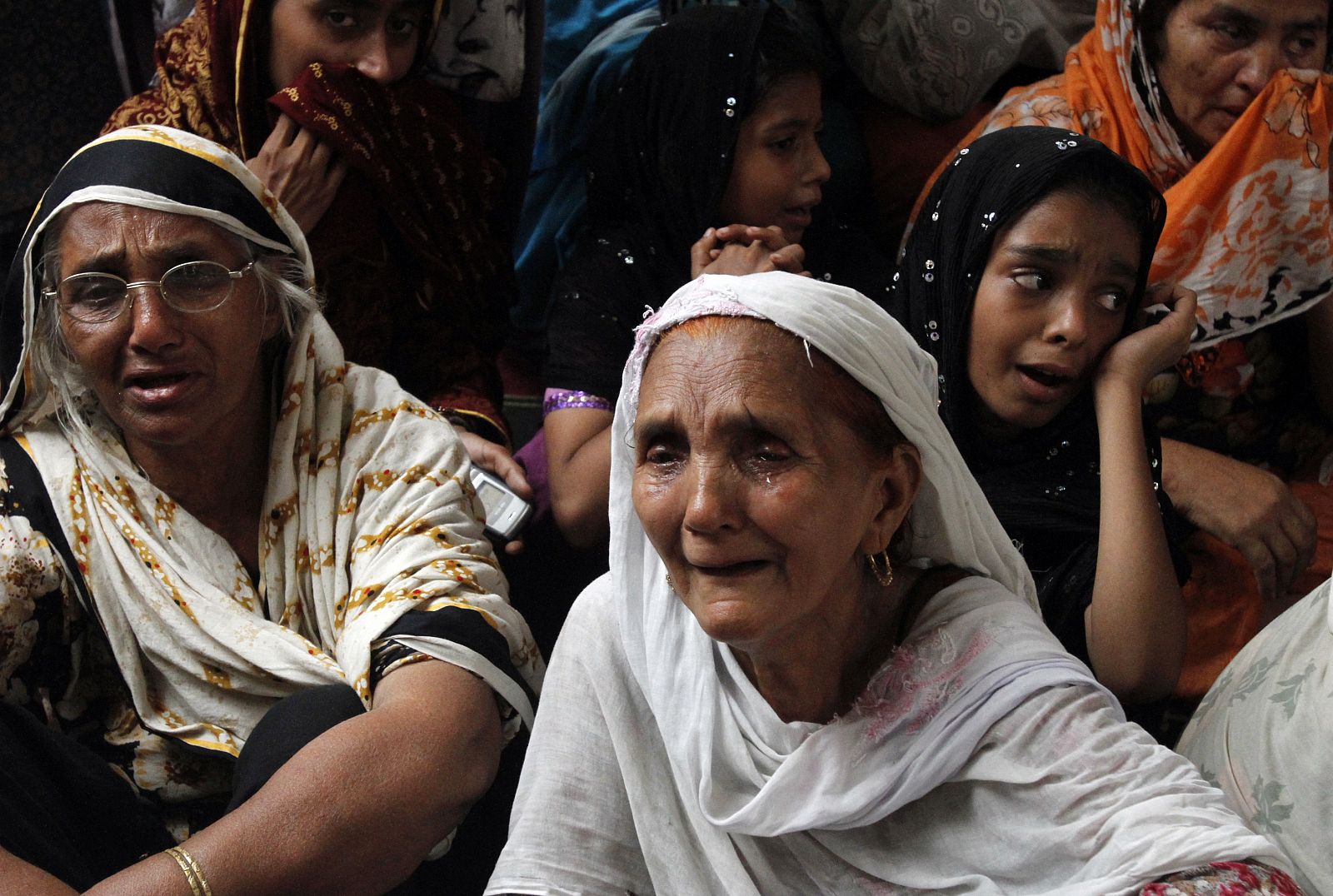 Familiares de uno de los fallecidos en el ataque suicida lloran junto a su ataúd en Lahore.